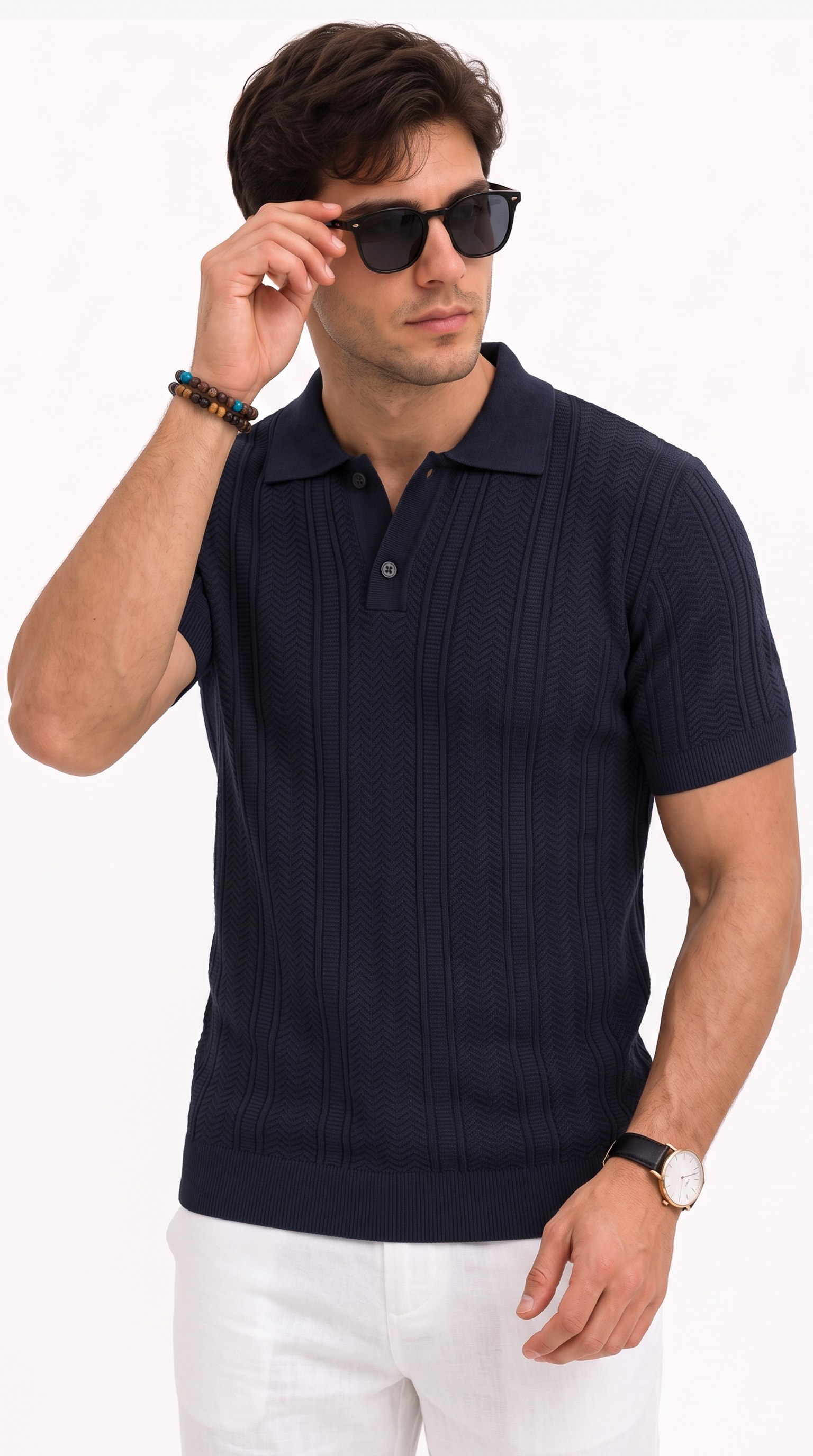 A man wearing a dark navy blue short-sleeve knit polo shirt with a textured chevron pattern, paired with white pants and black sunglasses, against a plain white background, from Meleche Fashion USA or Meléche (short as (Mé))