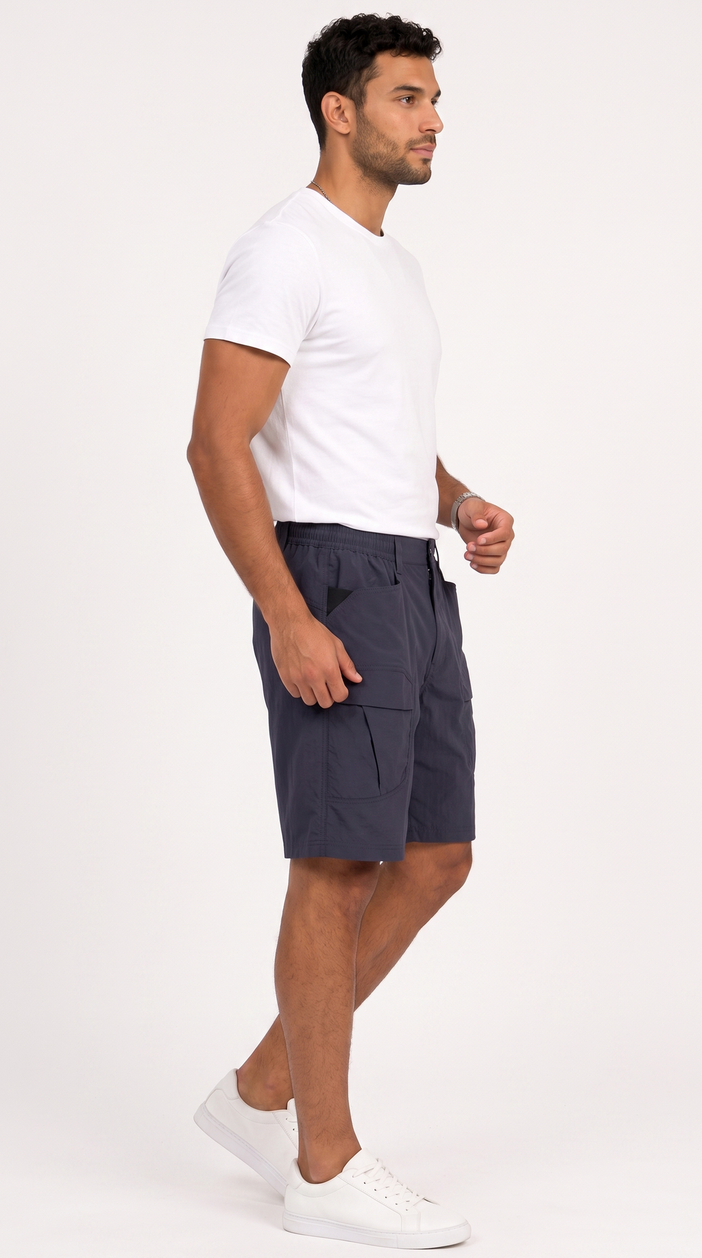 A man in a white t-shirt and white sneakers wearing navy blue cargo shorts, shown in profile against a plain white studio background, from Meleche Fashion USA or Meléche (short as (Mé))