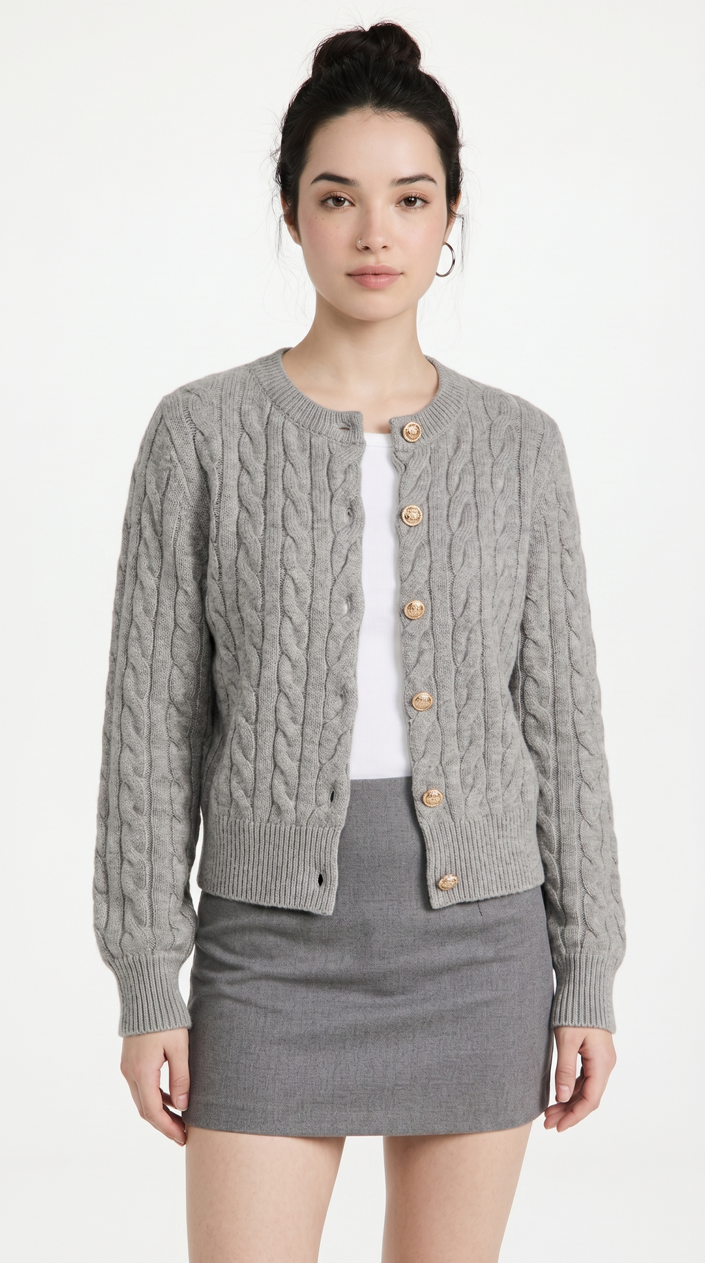 Woman wearing a gray cable knit cardigan over a white shirt and gray skirt on a white background from Meleche or Meléche (short as (Mé))