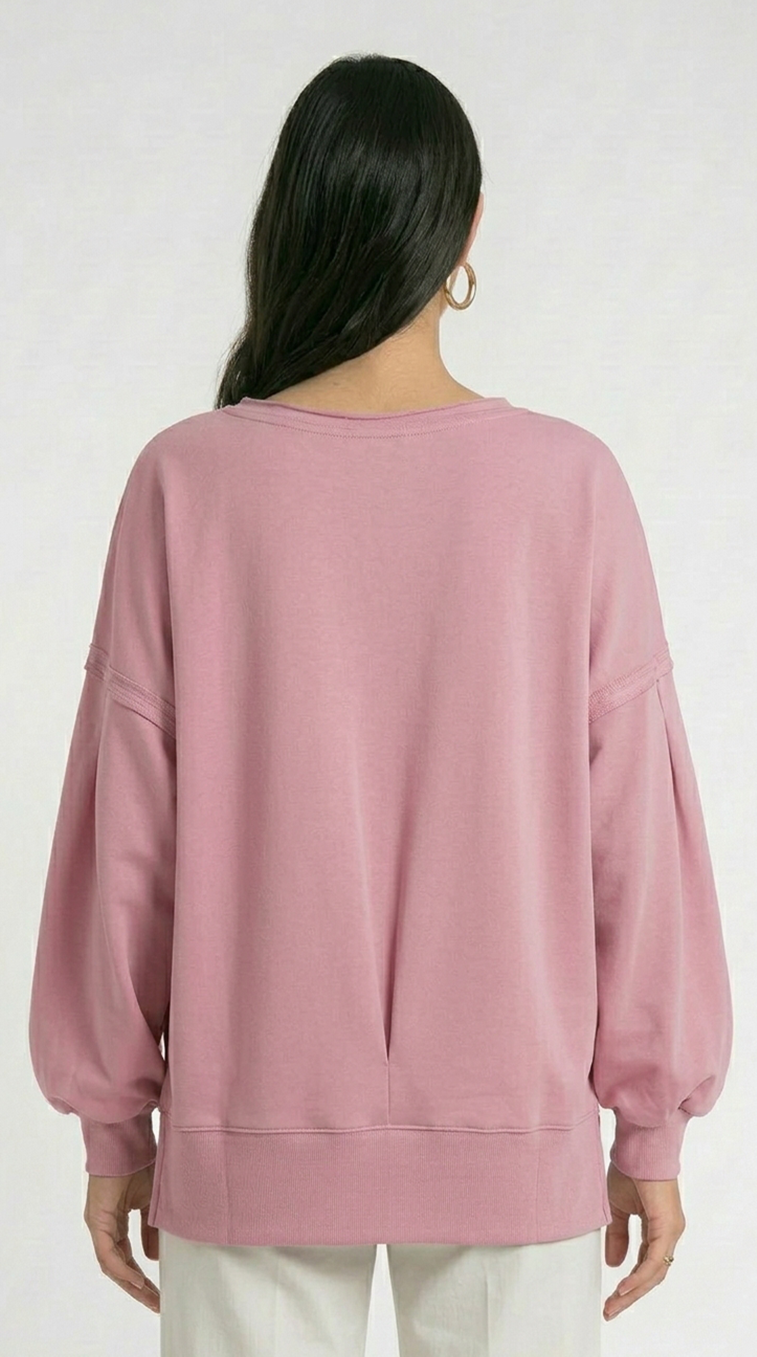 Person wearing a pink sweatshirt on a white background