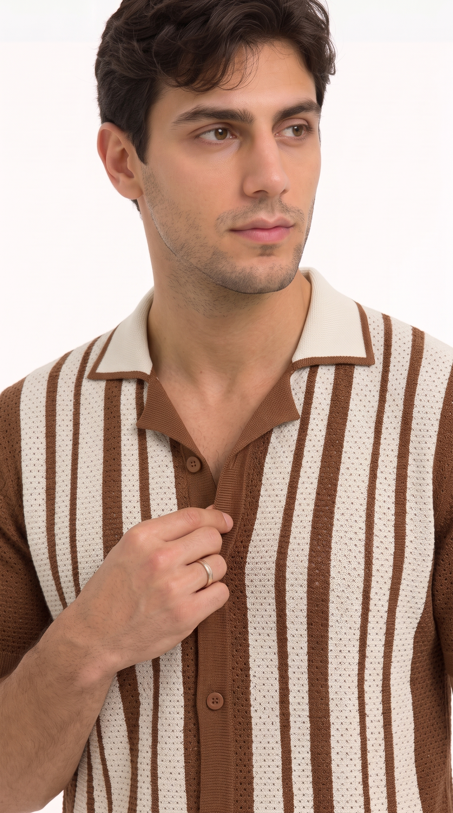 A man wearing a brown and cream vertically striped knit polo shirt, adjusting the collar with one hand against a plain white background, from Meleche Fashion USA or Meléche (short as (Mé))