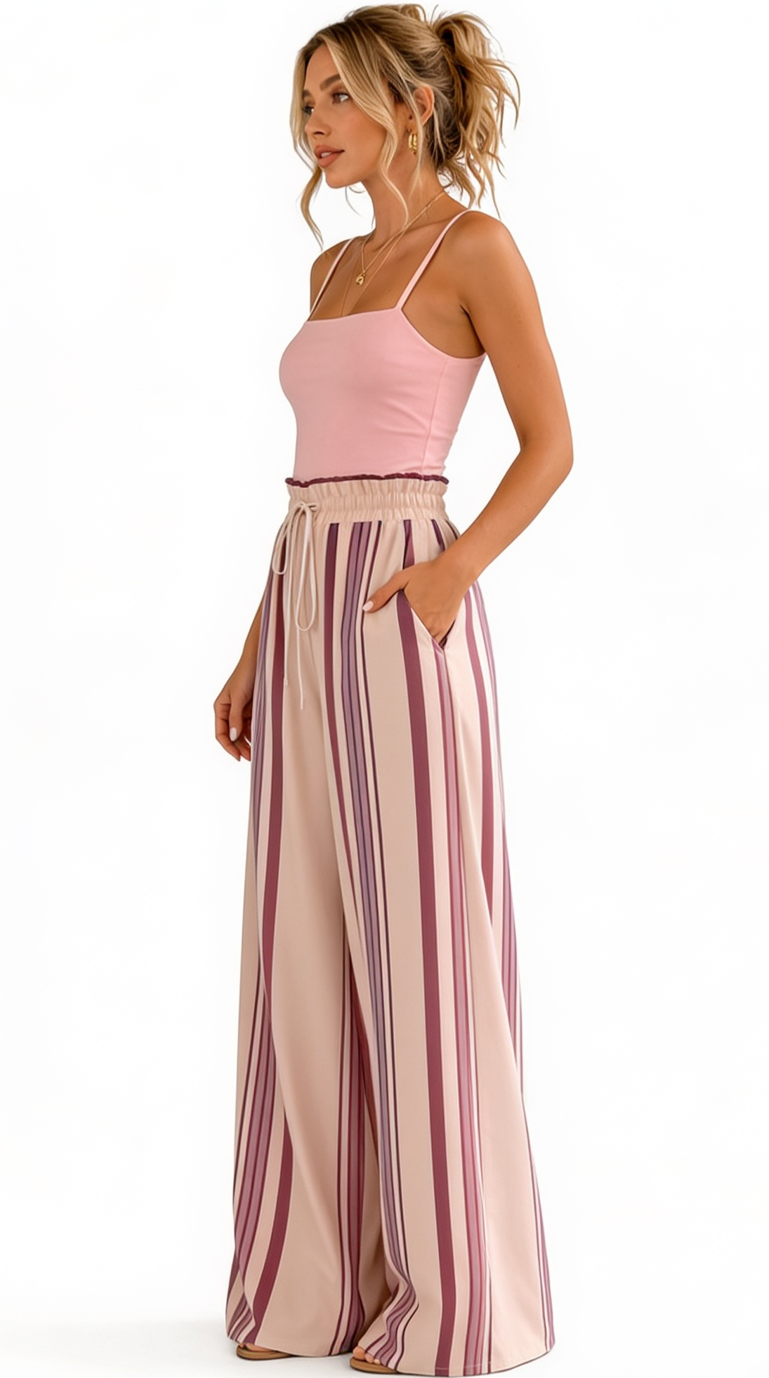 Woman wearing a pink top and striped pants on a white background