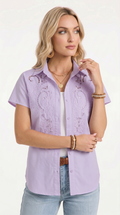 Woman wearing a light purple embroidered shirt with a plain background, from Meleche Fashion USA or Meléche (short as (Mé))