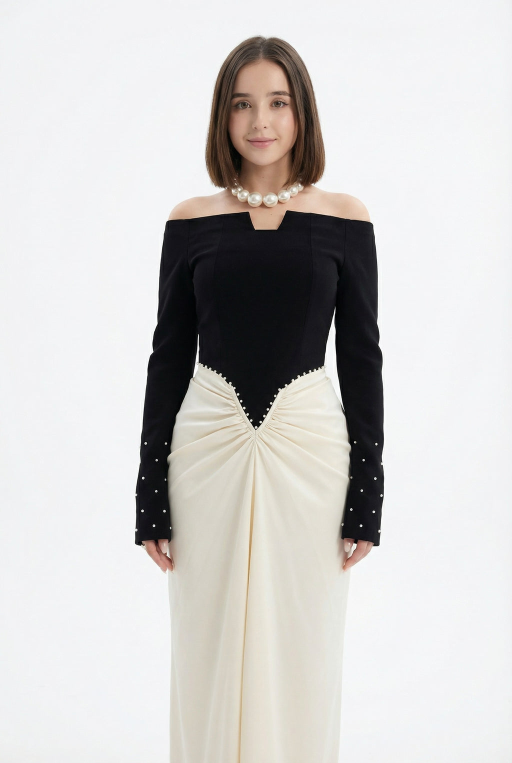 Woman in black top and white skirt holding a clutch in a room with white curtains.