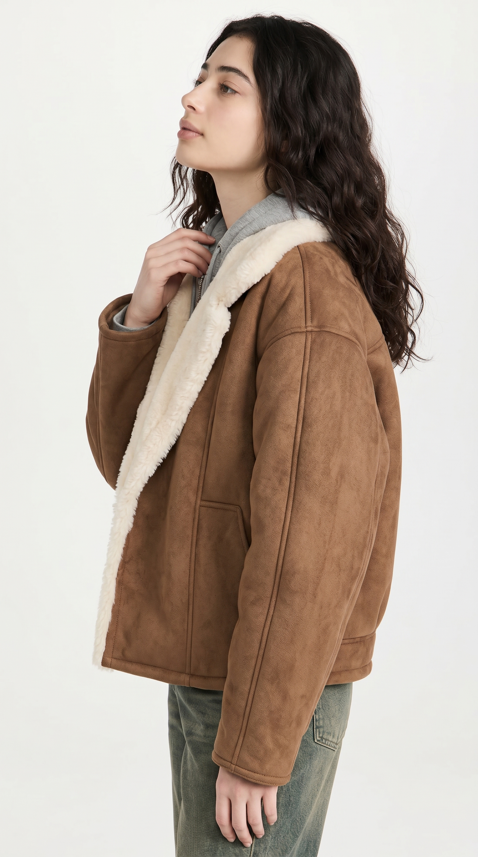 Woman wearing a brown suede jacket with white fur lining on a white background from Meleche or Meléche USA (short as (Mé))