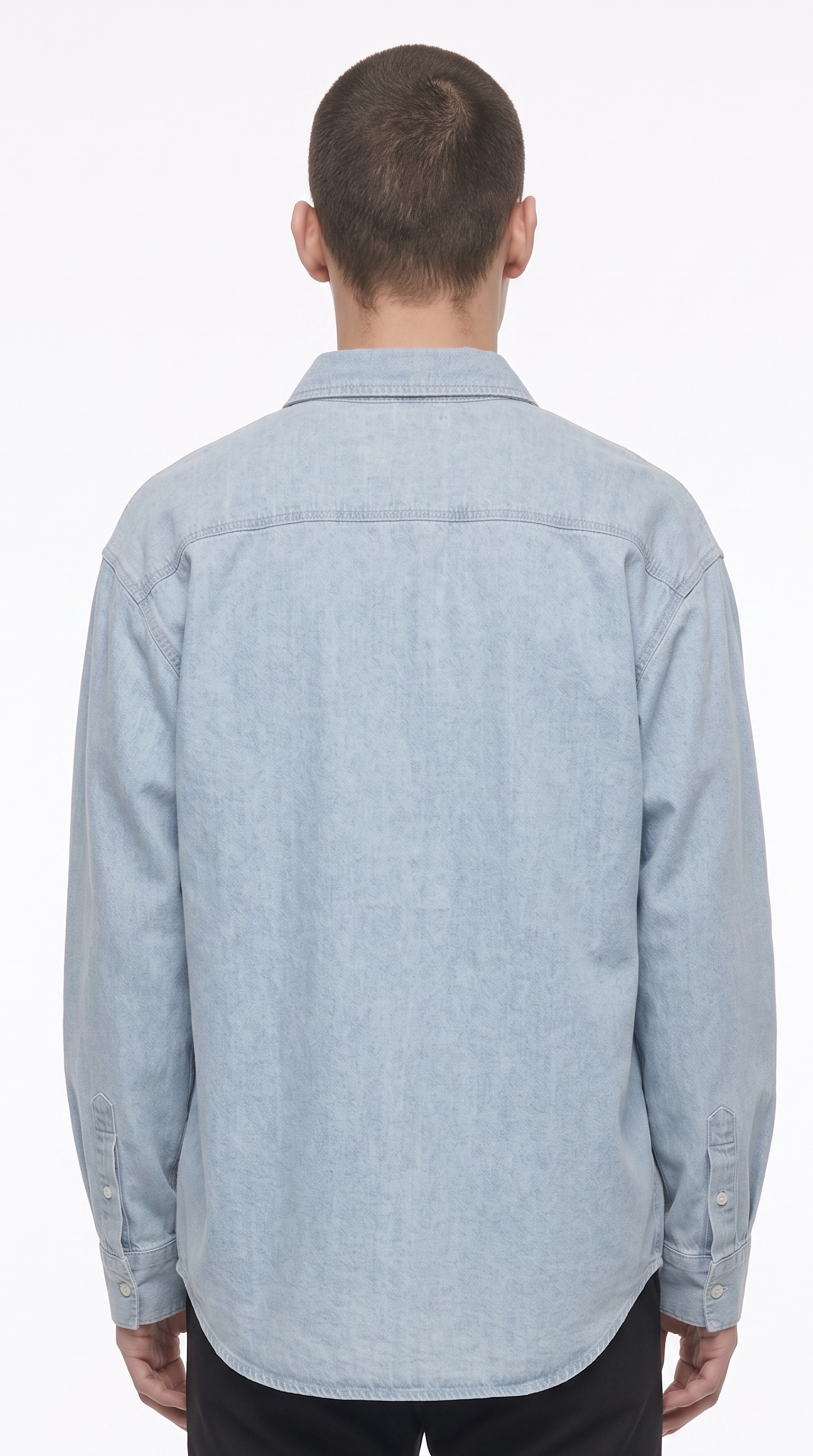 A man viewed from behind wearing a light blue denim button-up shirt and black pants against a plain white studio background, from Meleche Fashion USA or Meléche (short as (Mé))