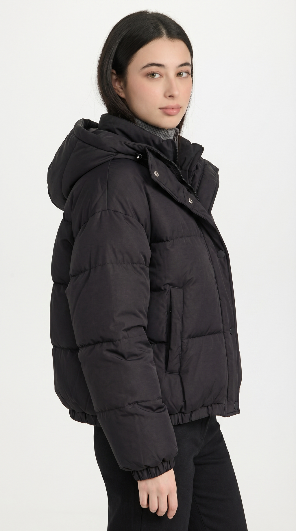 Person wearing a black puffer jacket on a white background from Meleche USA or Meléche (short as (Mé))