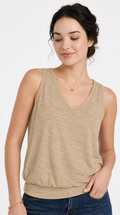 Woman wearing a beige sleeveless top and blue jeans on a white background, from Meleche Fashion USA or Meléche (short as (Mé))