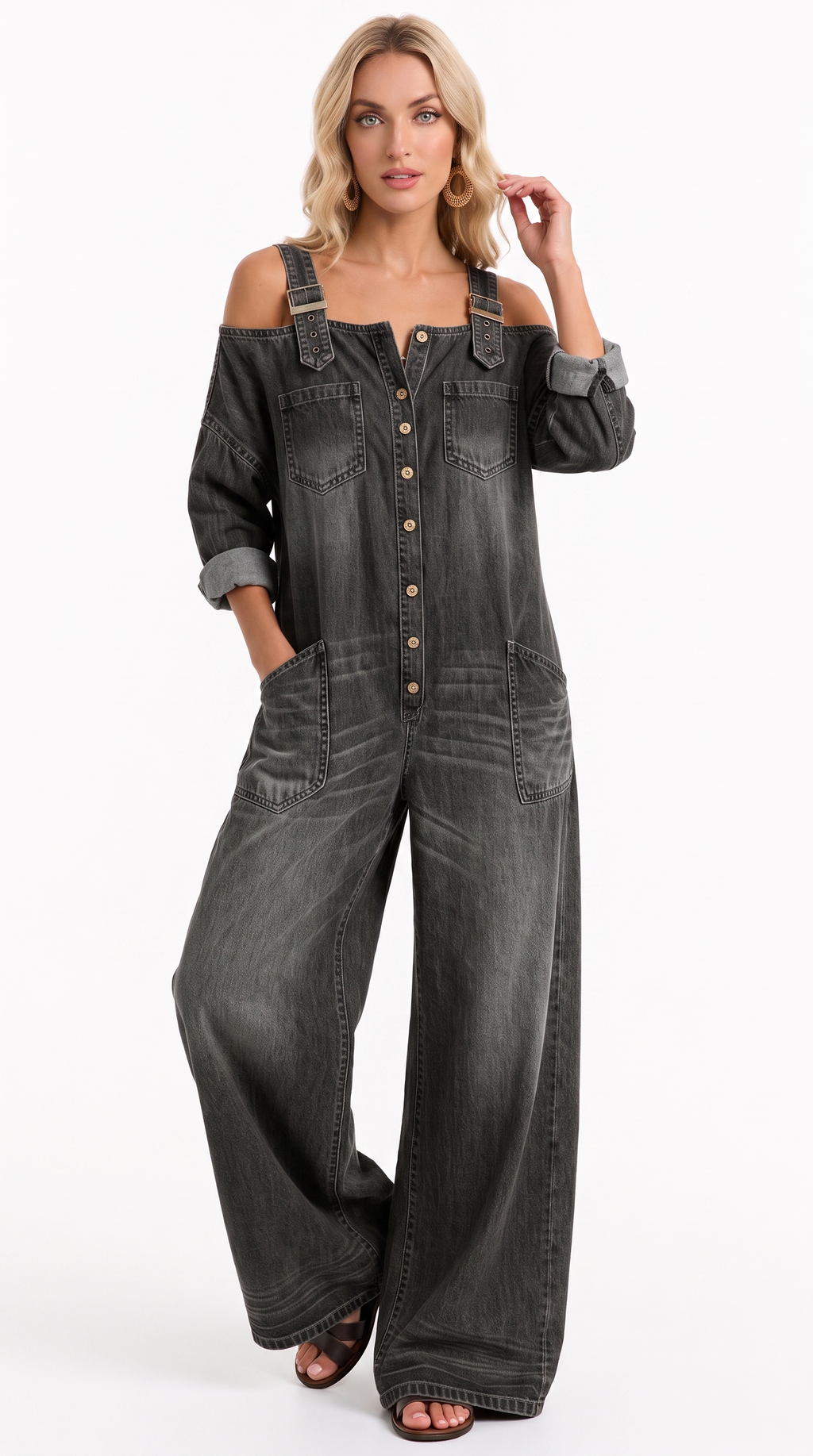 A woman modeling a dark gray washed denim overall jumpsuit with shoulder cutouts, button-front closure, and wide legs, photographed against a plain white studio background, from Meleche Fashion USA or Meléche (short as (Mé))