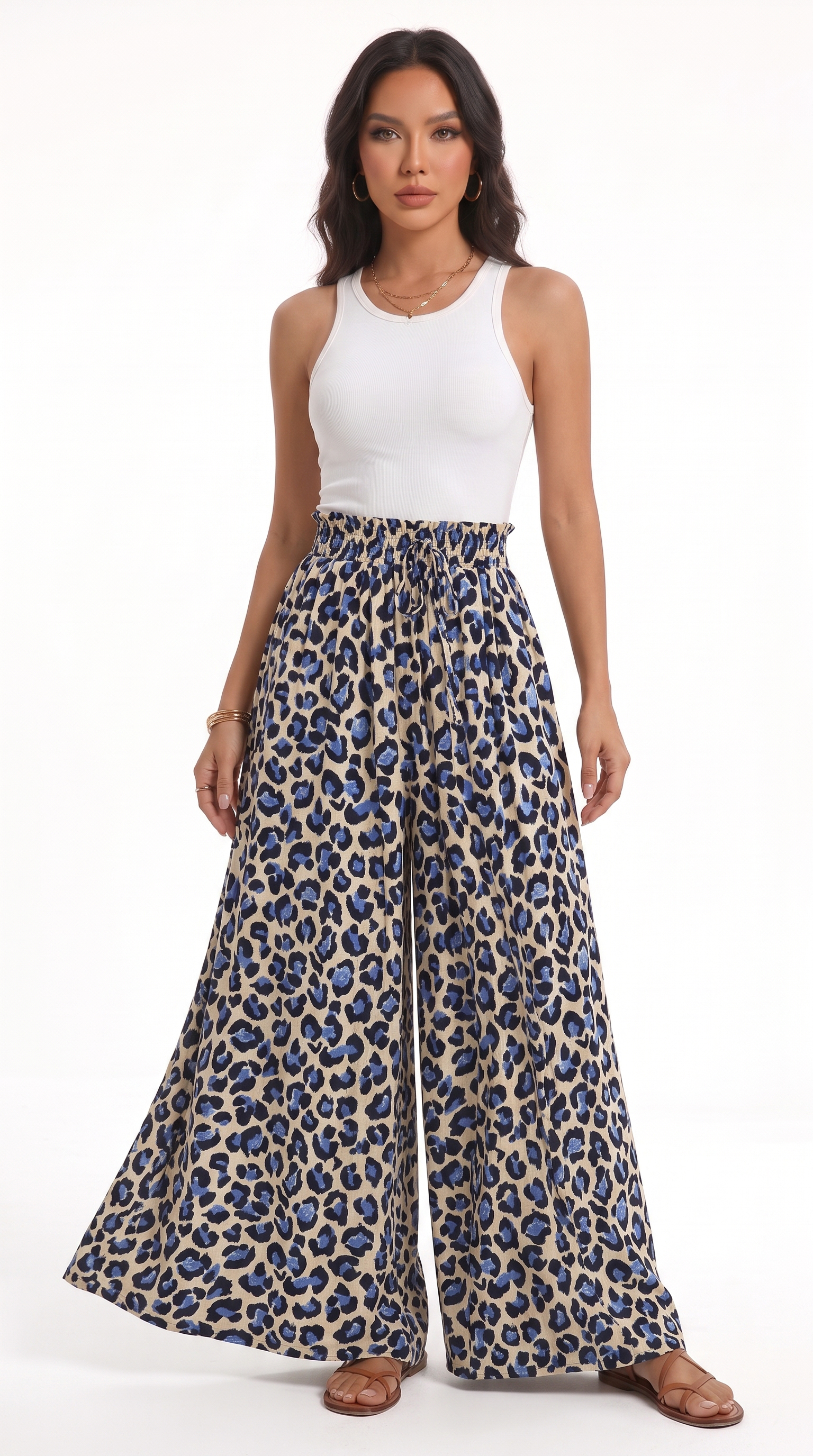 A woman modeling a pair of high-waisted, wide-leg pants with a blue and beige leopard print, paired with a white sleeveless top, against a plain white background, from Meleche Fashion USA or Meléche (short as (Mé))