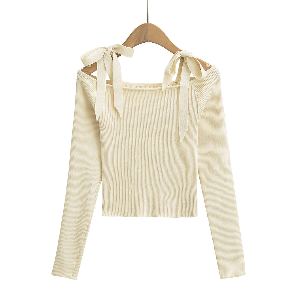 Beige ribbed sweater with bow details on a hanger from Meleche or Meléche (short as (Mé))