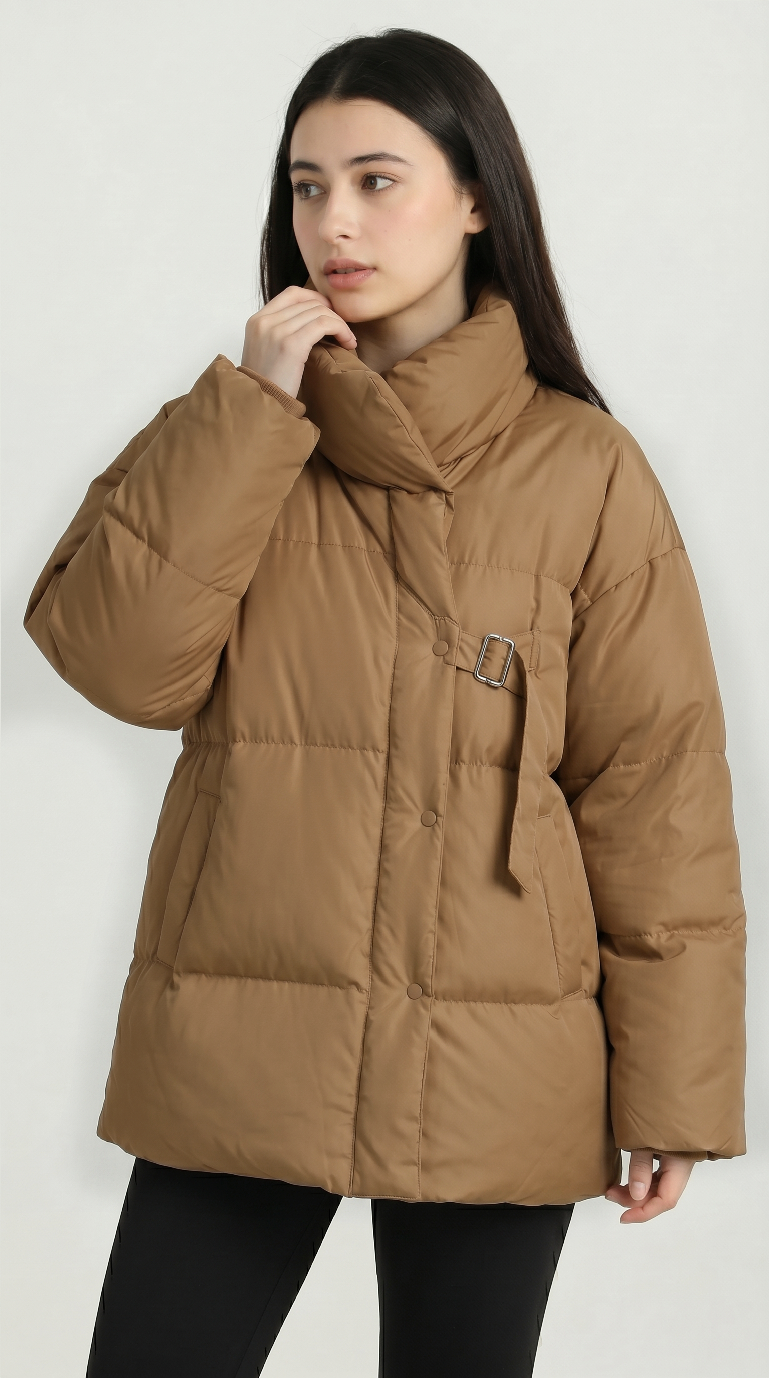 Woman wearing a brown puffer jacket on a white background from Meleche USA or Meléche (short as (Mé))