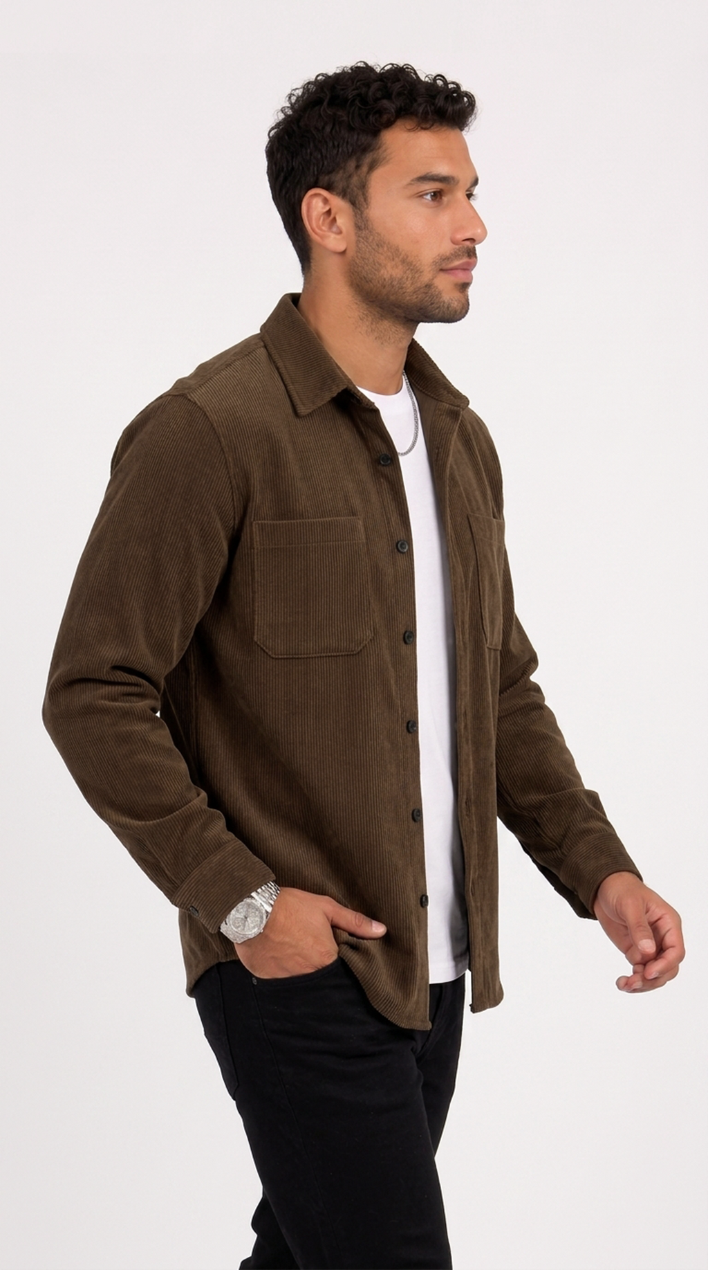 A man wearing a brown corduroy button-up shirt over a white t-shirt and black pants, standing against a plain white studio background, from Meleche Fashion USA or Meléche (short as (Mé))