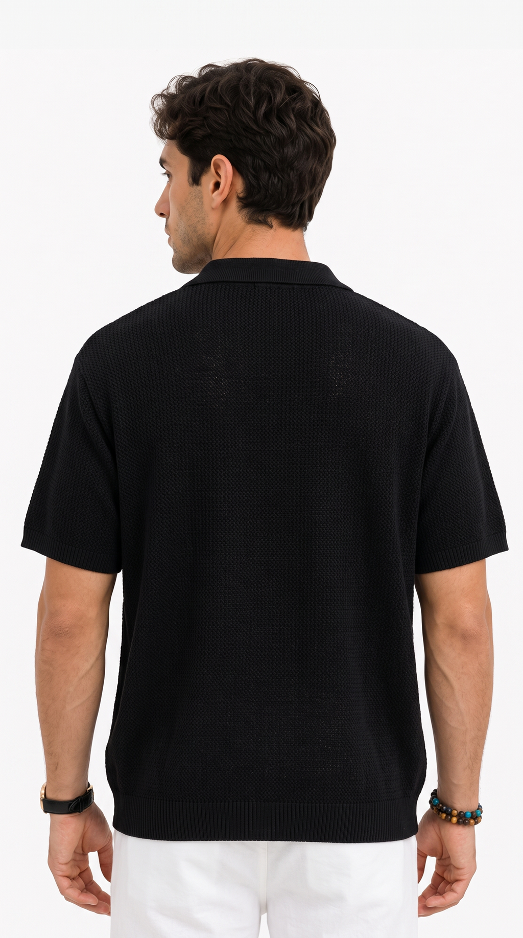 A man viewed from the back wearing a black short-sleeve knit polo shirt and white pants, standing against a plain white studio background, from Meleche Fashion USA or Meléche (short as (Mé))