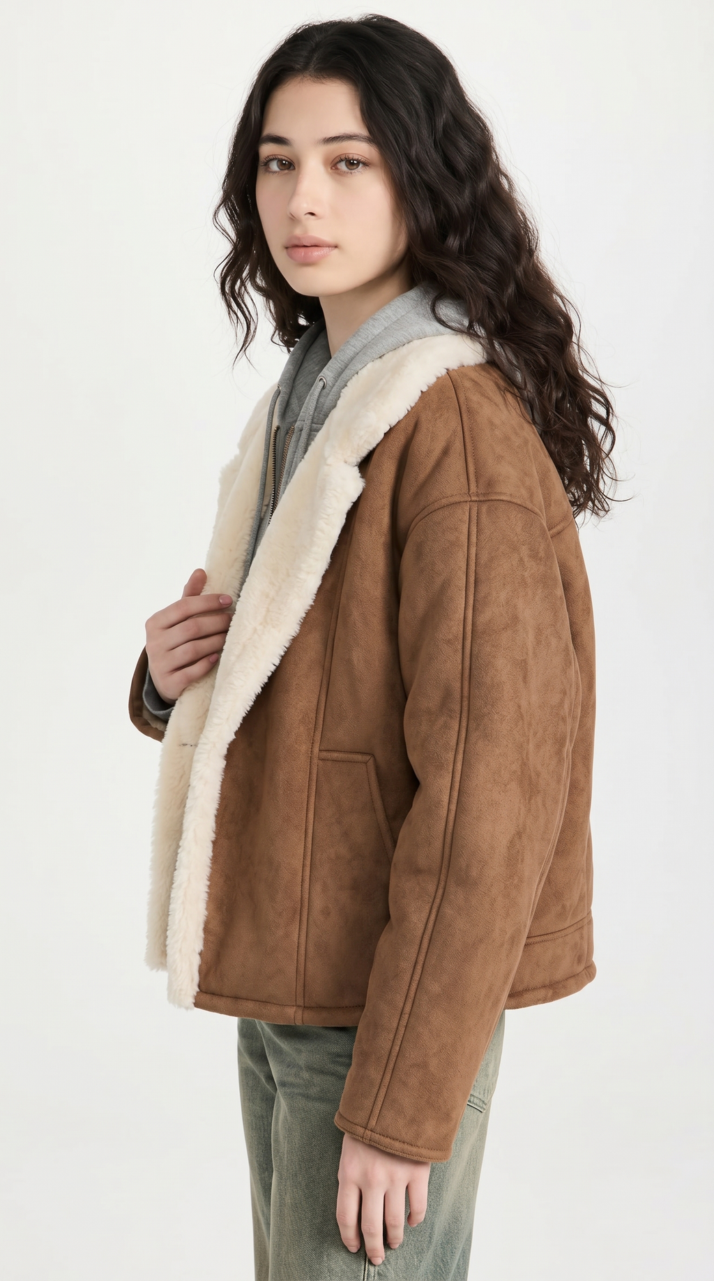 Woman wearing a brown shearling jacket on a white background from Meleche USA or Meléche (short as (Mé))