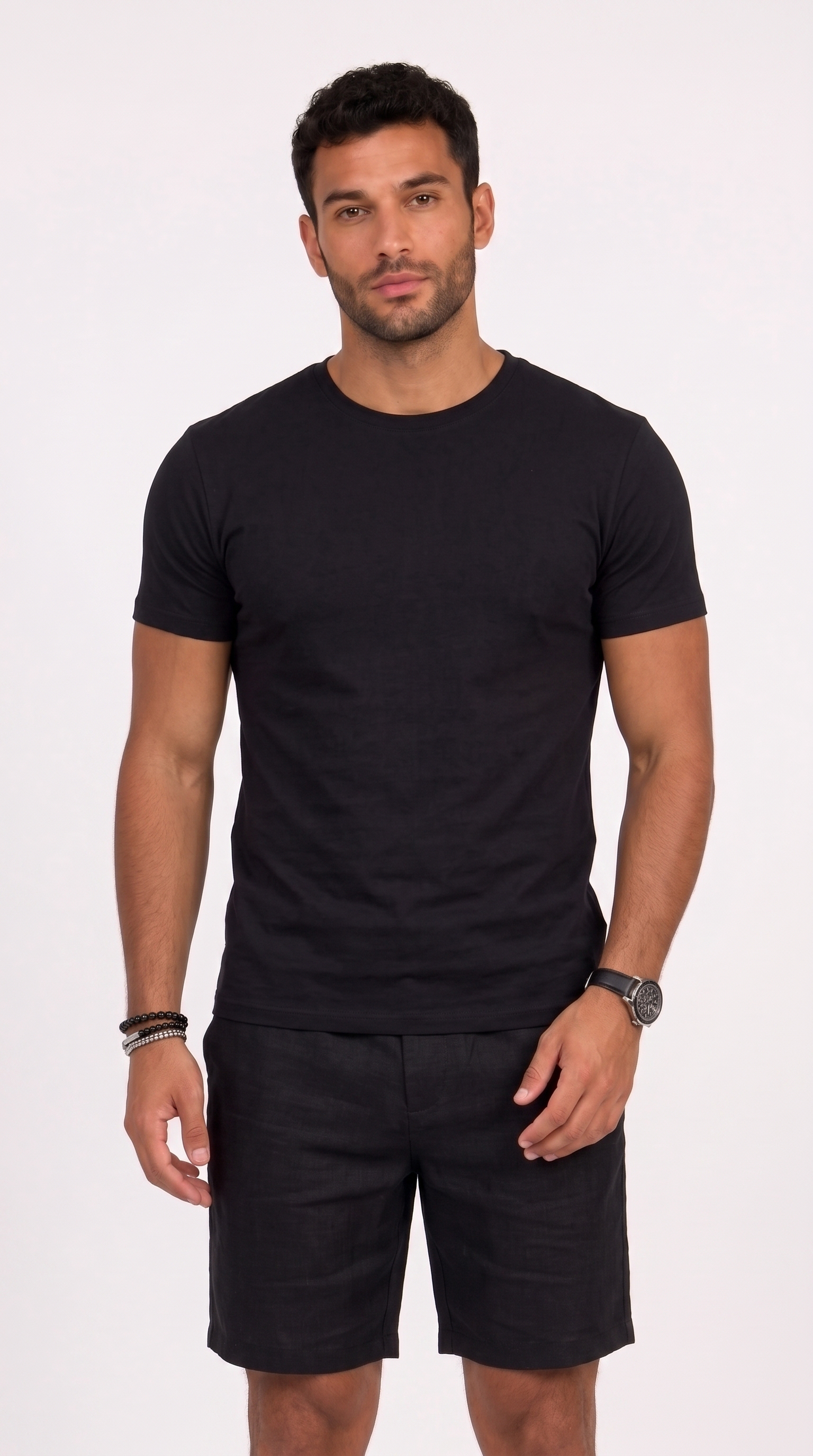 A man wearing a black short-sleeve crewneck t-shirt and black shorts, standing against a plain white studio background, from Meleche Fashion USA or Meléche (short as (Mé))