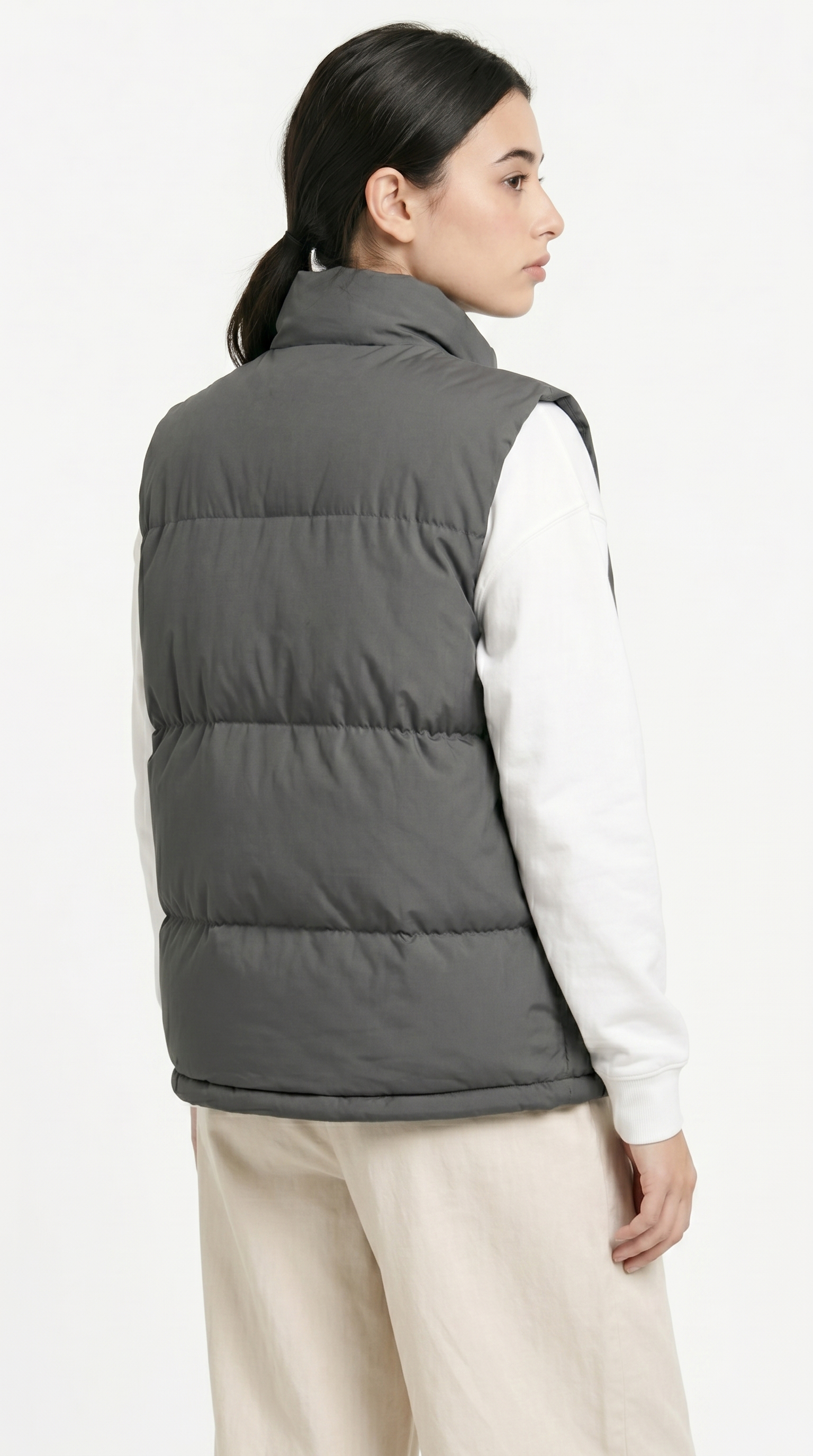 Person wearing a gray puffer vest over a white shirt on a white background from Meleche Fashion USA or Meléche (short as (Mé))