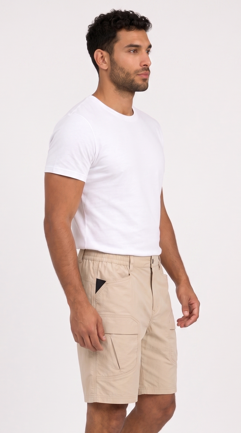A man wearing a white crew-neck t-shirt and beige cargo shorts, shown from a side profile against a light gray studio background, from Meleche Fashion USA or Meléche (short as (Mé))