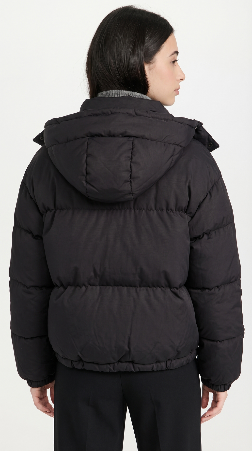 Person wearing a black puffer jacket on a white background from Meleche or Meléche USA (short as (Mé))