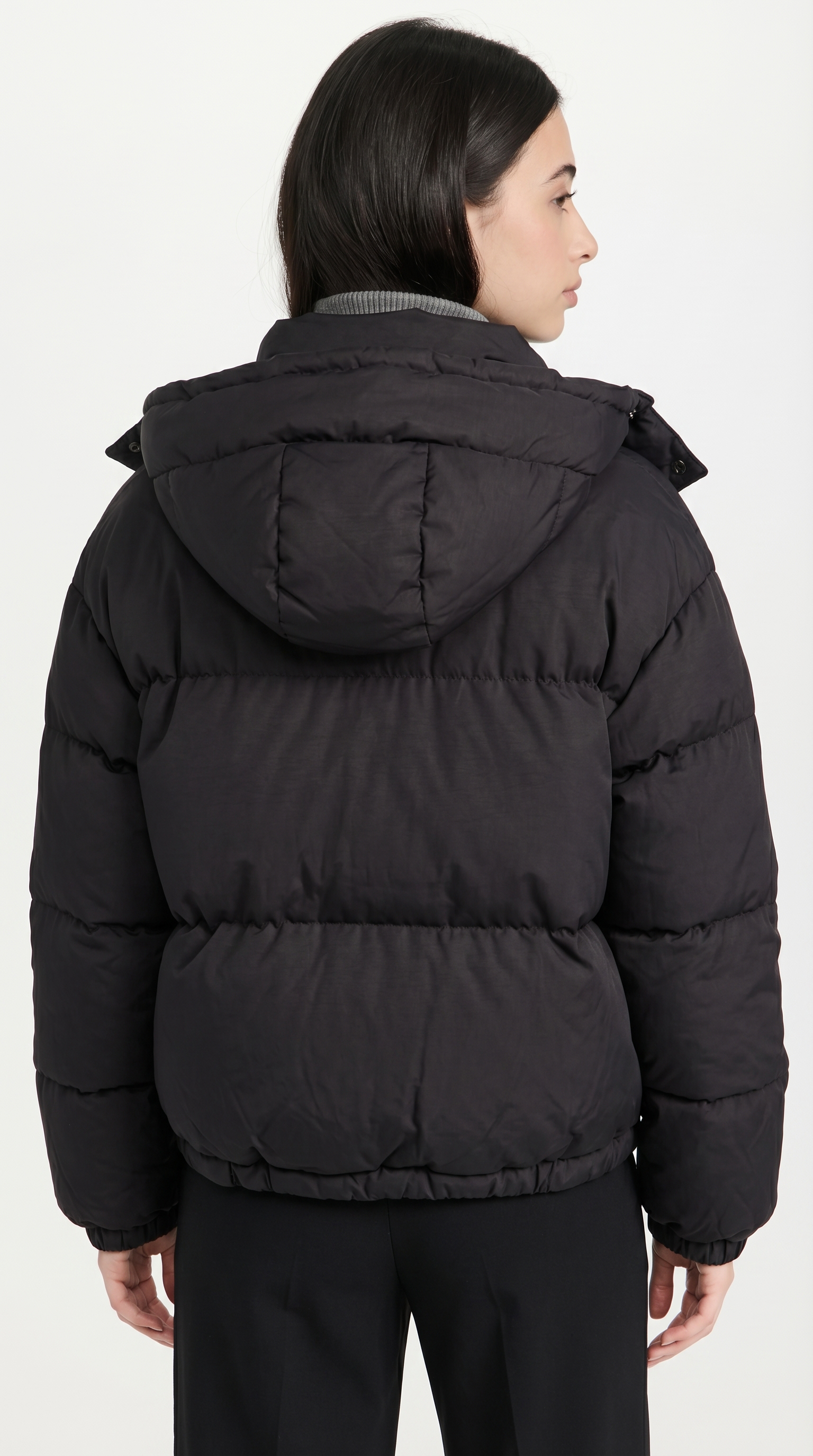 Person wearing a black puffer jacket on a white background from Meleche or Meléche USA (short as (Mé))