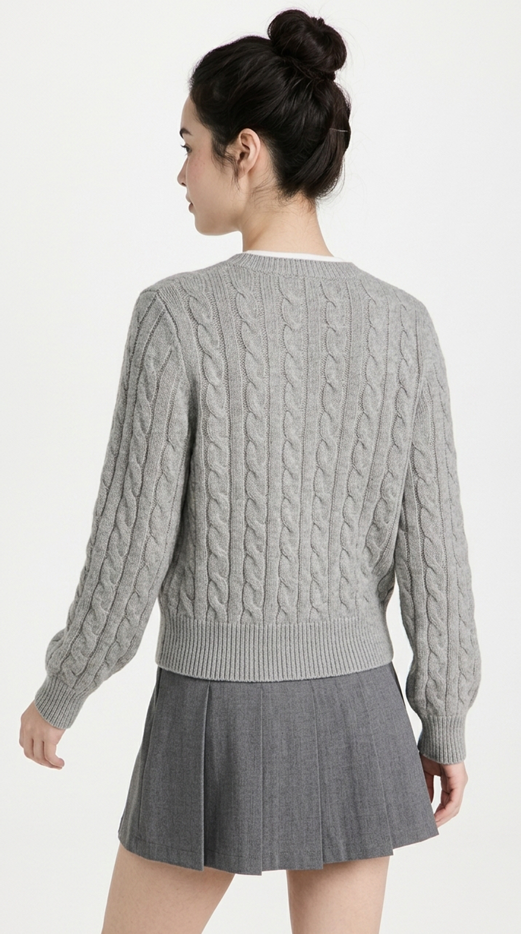 Woman wearing a gray cable knit sweater and skirt on a white background from Meleche or Meléche (short as (Mé))