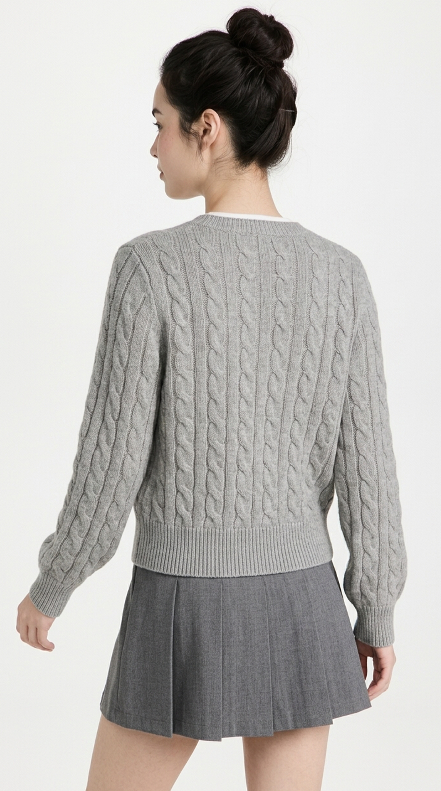 Woman wearing a gray cable knit sweater and skirt on a white background from Meleche or Meléche (short as (Mé))