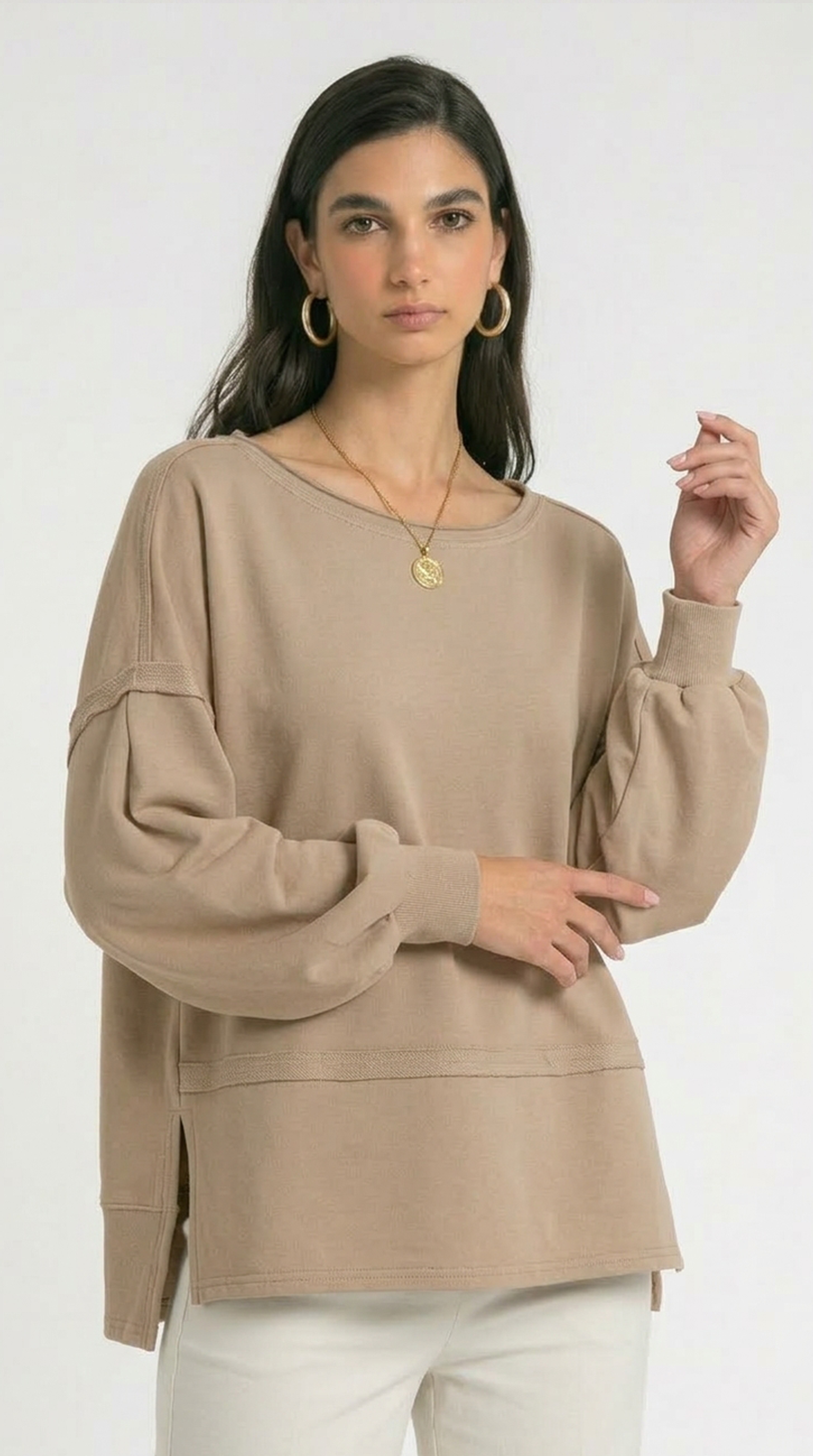 Woman wearing a beige sweater on a white background