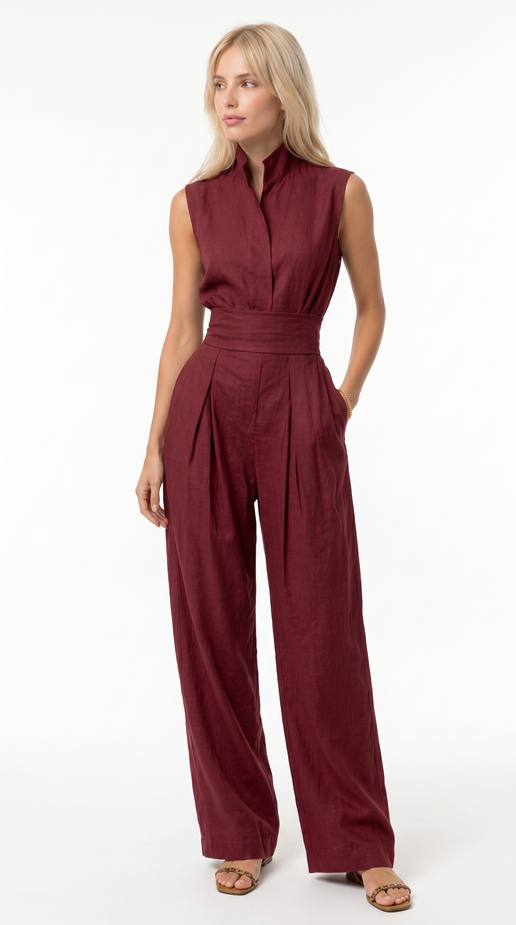 A woman modeling a sleeveless burgundy jumpsuit with a high collar, defined waist, and wide-leg pants against a plain white studio background, from Meleche Fashion USA or Meléche (short as (Mé))