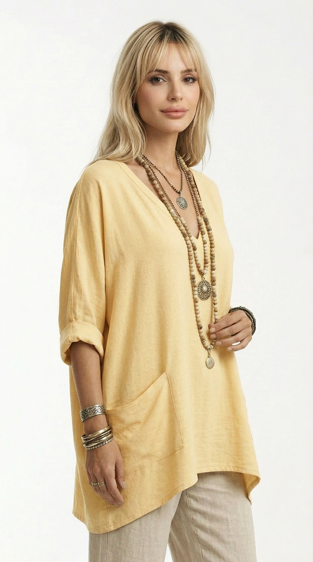 Woman wearing a yellow top and beige pants with a white background from Meleche or Meléche (short as (Mé))