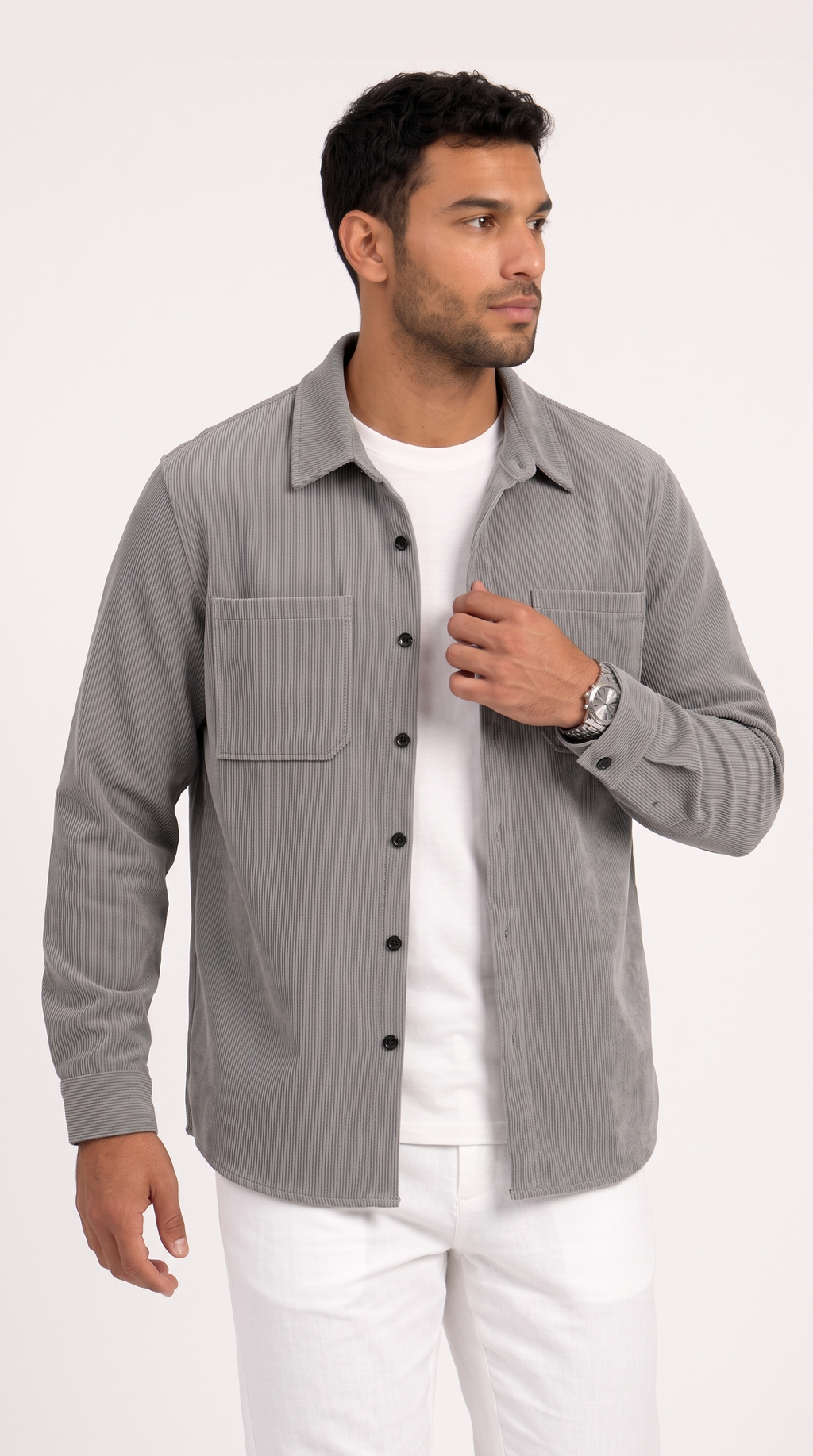A man wearing a light gray long-sleeve button-up shirt over a white t-shirt and white pants, standing against a plain white studio background, from Meleche Fashion USA or Meléche (short as (Mé))