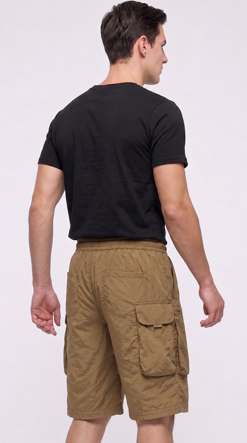 A man shown from the back wearing a black short-sleeve t-shirt and tan cargo shorts against a plain light gray studio background, from Meleche Fashion USA or Meléche (short as (Mé))