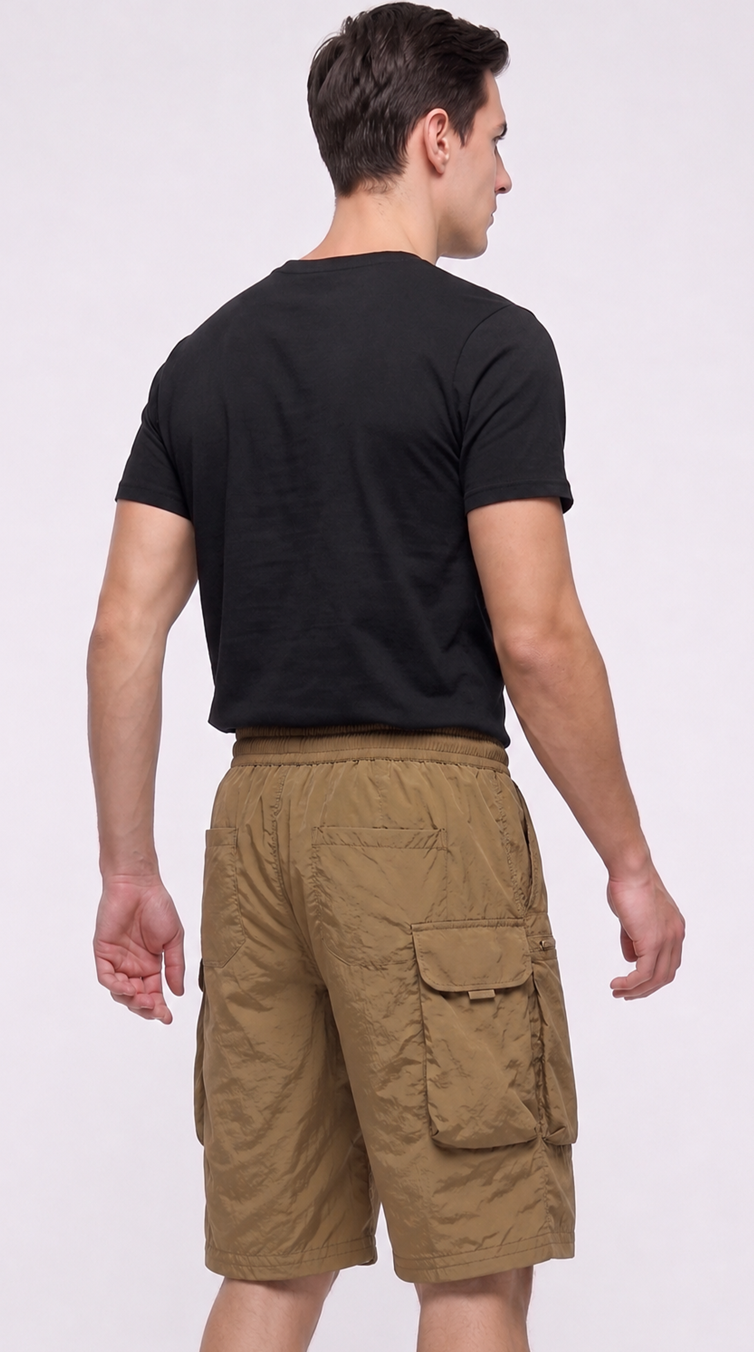 A man shown from the back wearing a black short-sleeve t-shirt and tan cargo shorts against a plain light gray studio background, from Meleche Fashion USA or Meléche (short as (Mé))