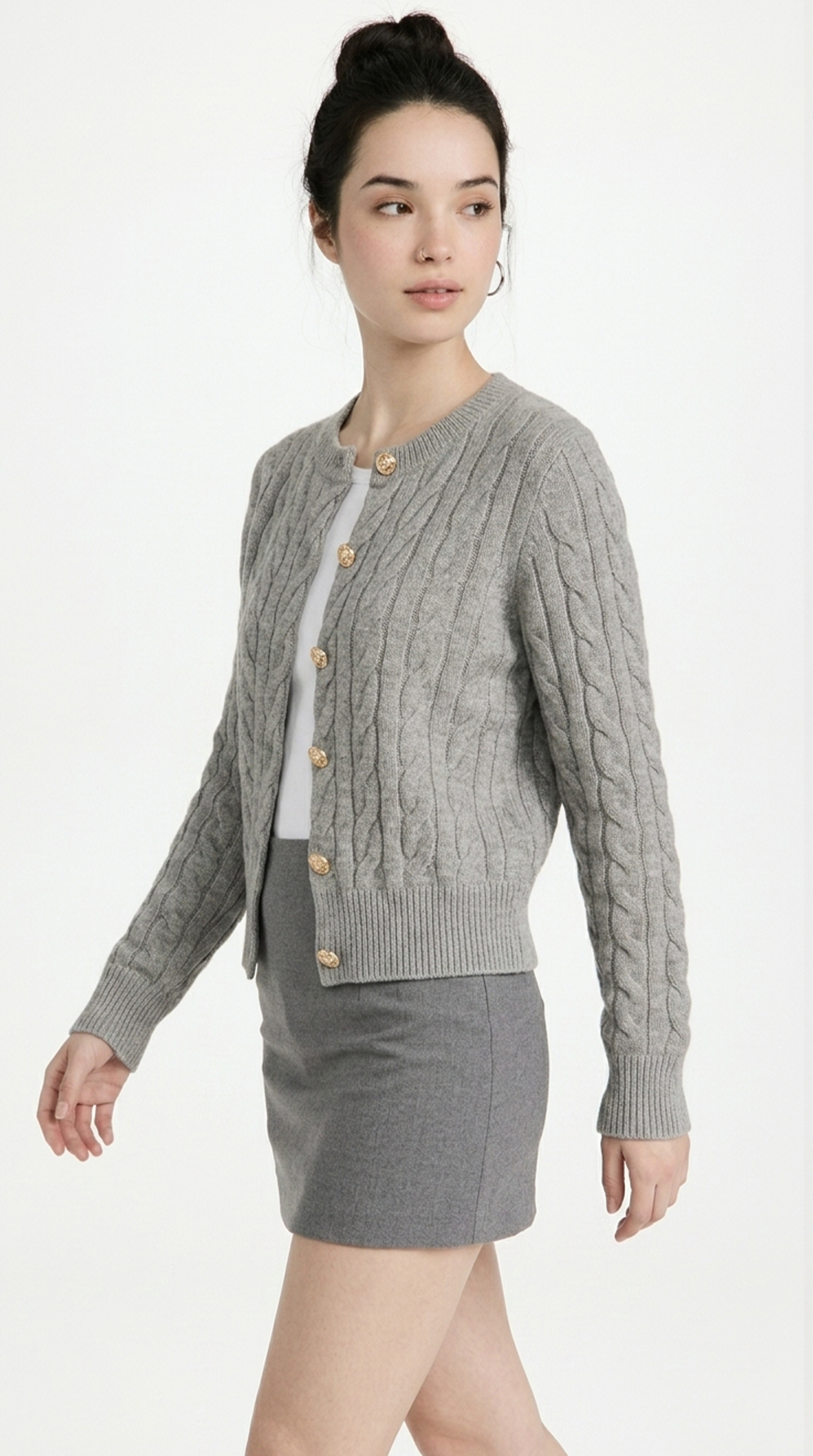 Woman wearing a gray cable knit cardigan over a skirt on a white background from Meleche or Meléche (short as (Mé))