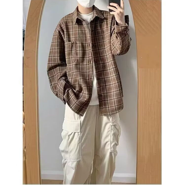 Person wearing a brown plaid shirt and beige pants taking a mirror selfie.