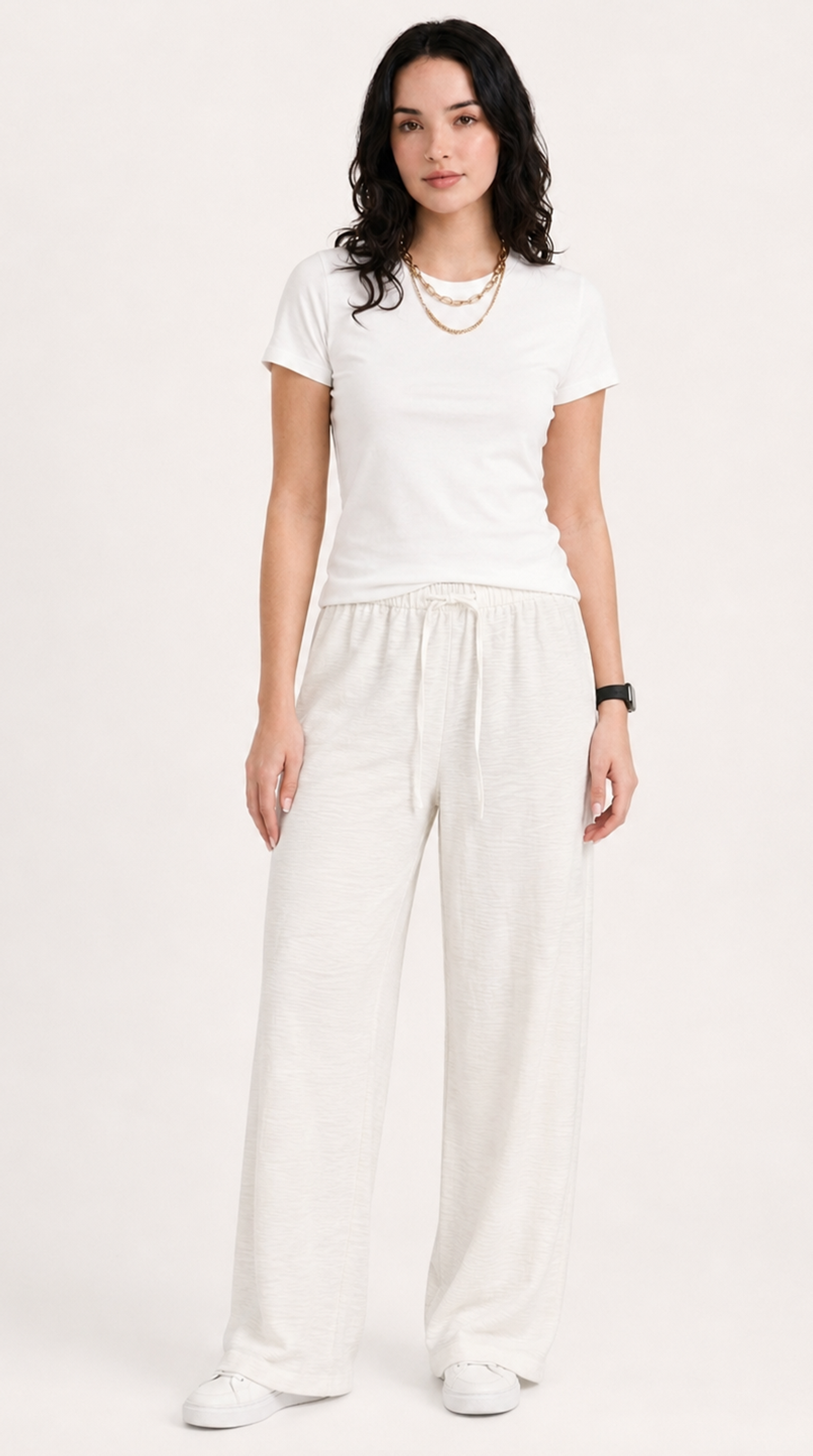 Woman wearing a white t-shirt and wide-leg pants on a plain background, from Meleche Fashion USA or Meléche (short as (Mé))