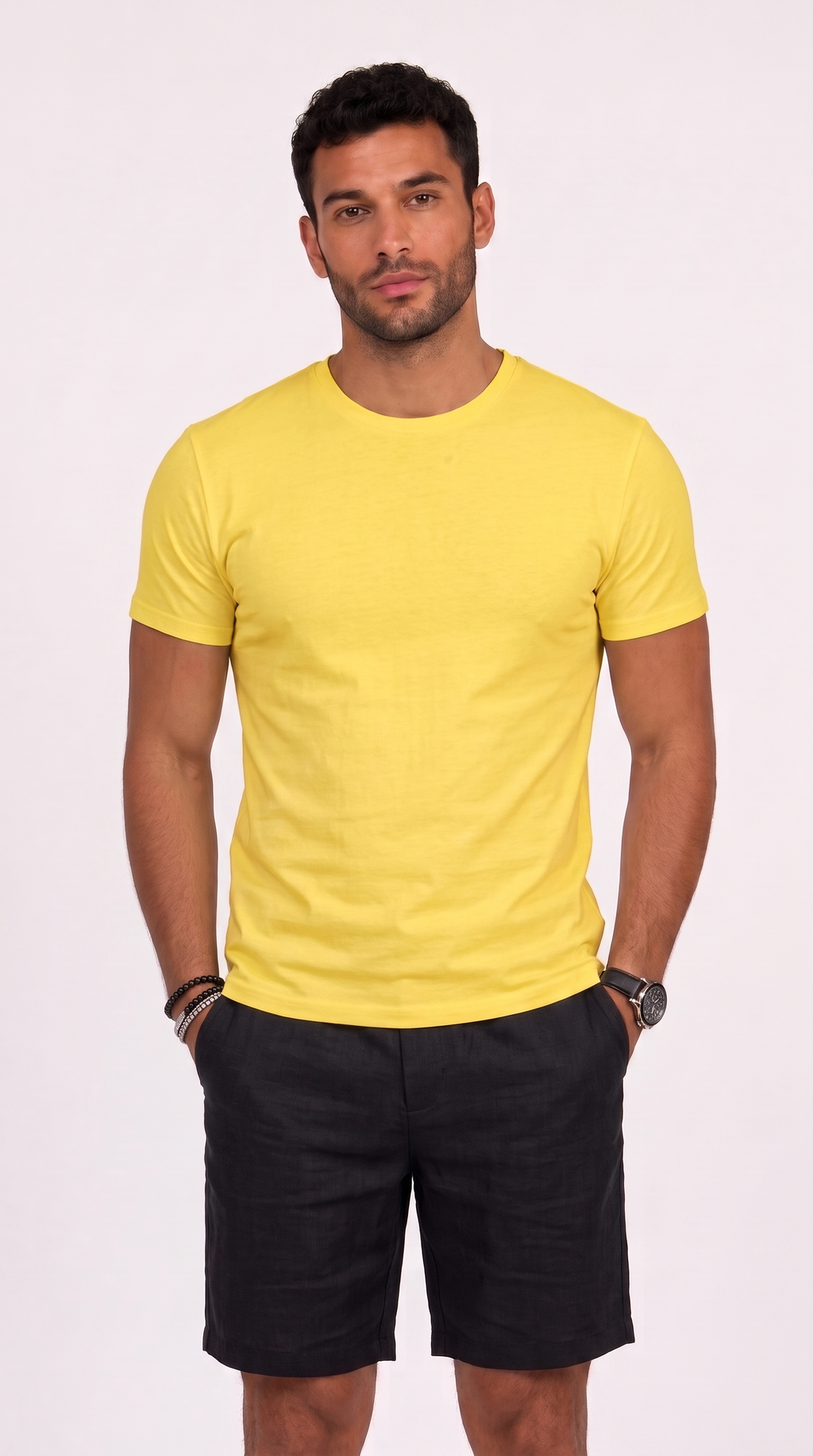 A man wearing a bright yellow short-sleeve crewneck t-shirt and black shorts, standing against a light off-white background, from Meleche Fashion USA or Meléche (short as (Mé))