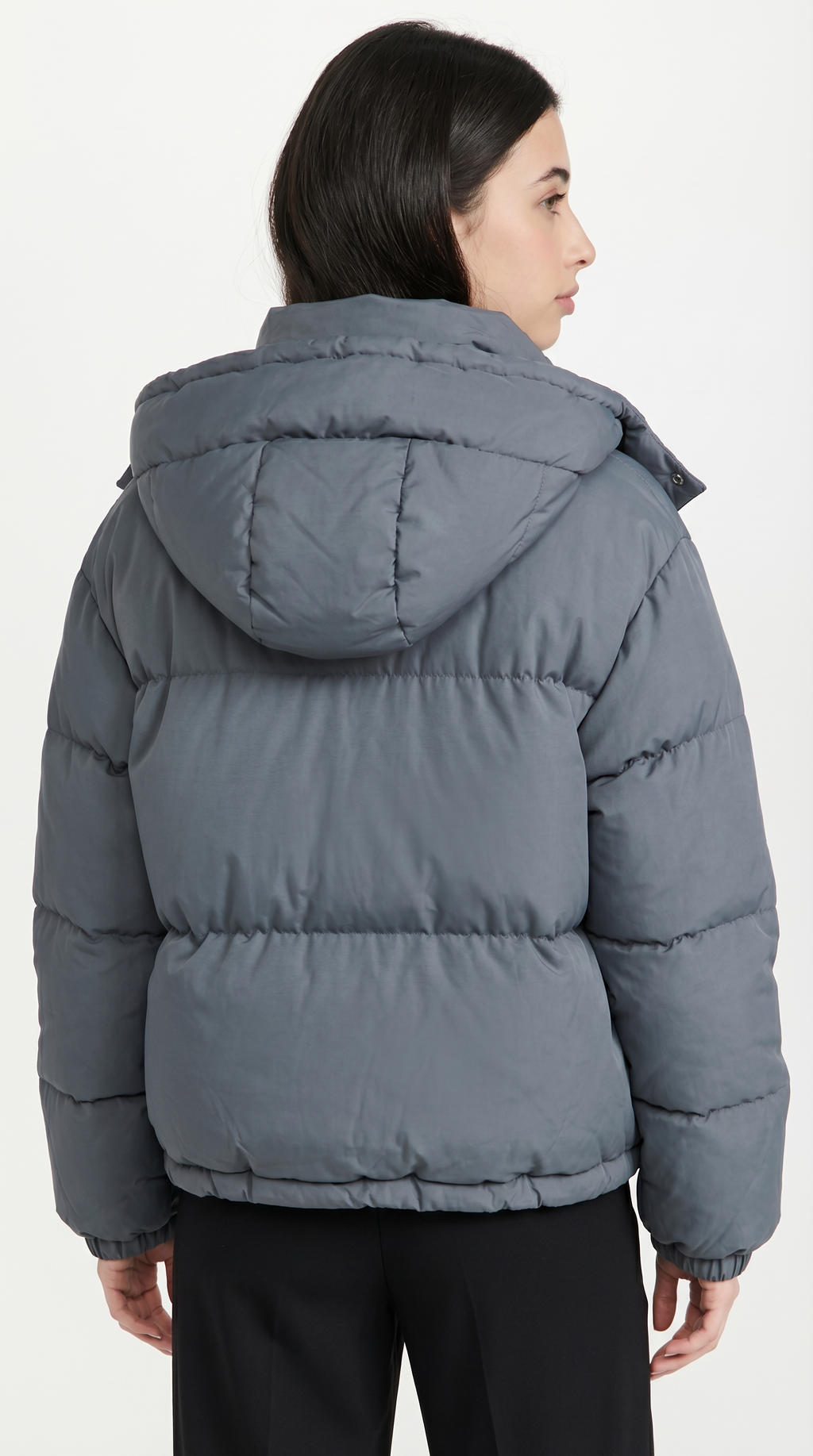 Person wearing a gray puffer jacket on a white background from Meleche or Meléche USA (short as (Mé))