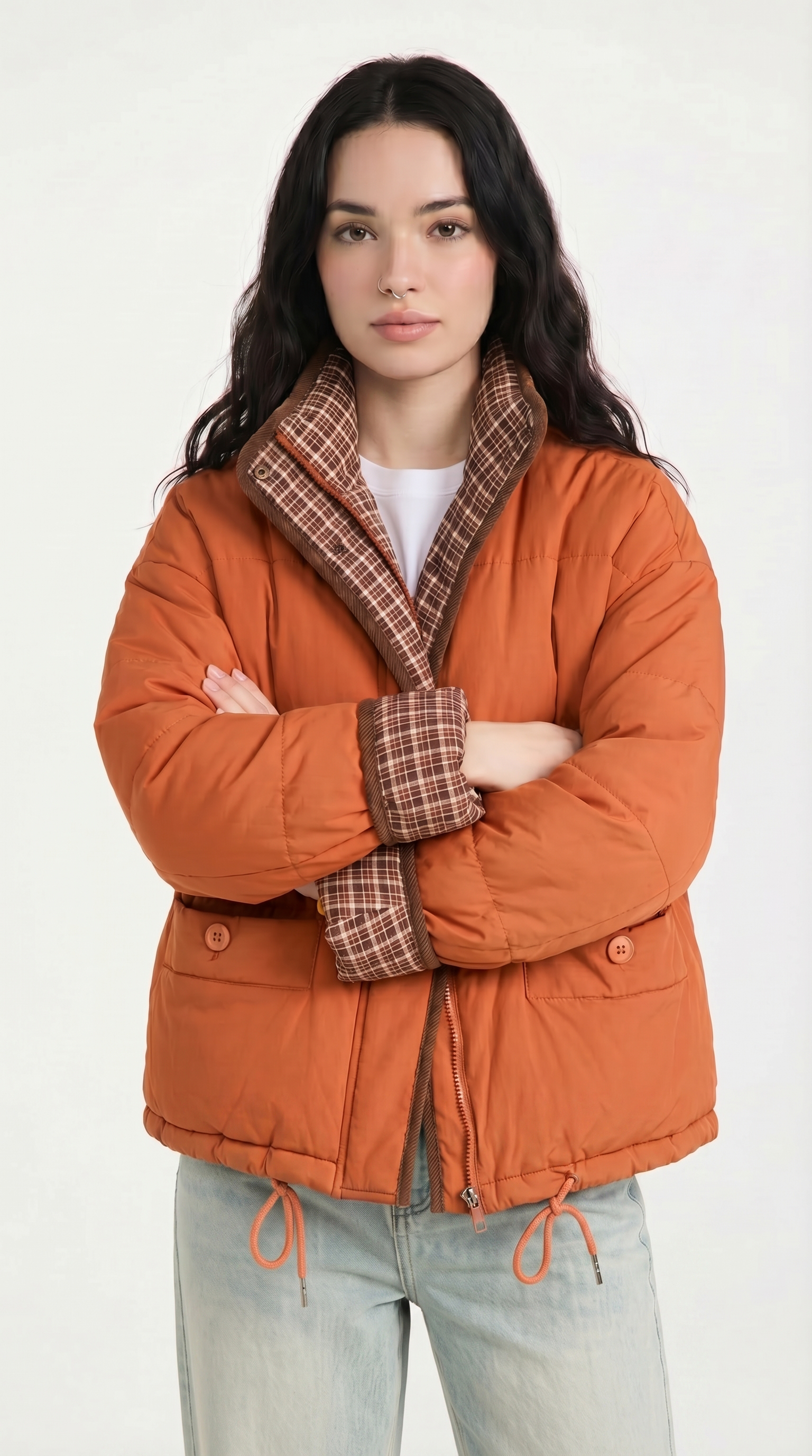 Woman wearing an orange puffer jacket with plaid lining on a white background from Meleche or Meléche USA (short as (Mé))