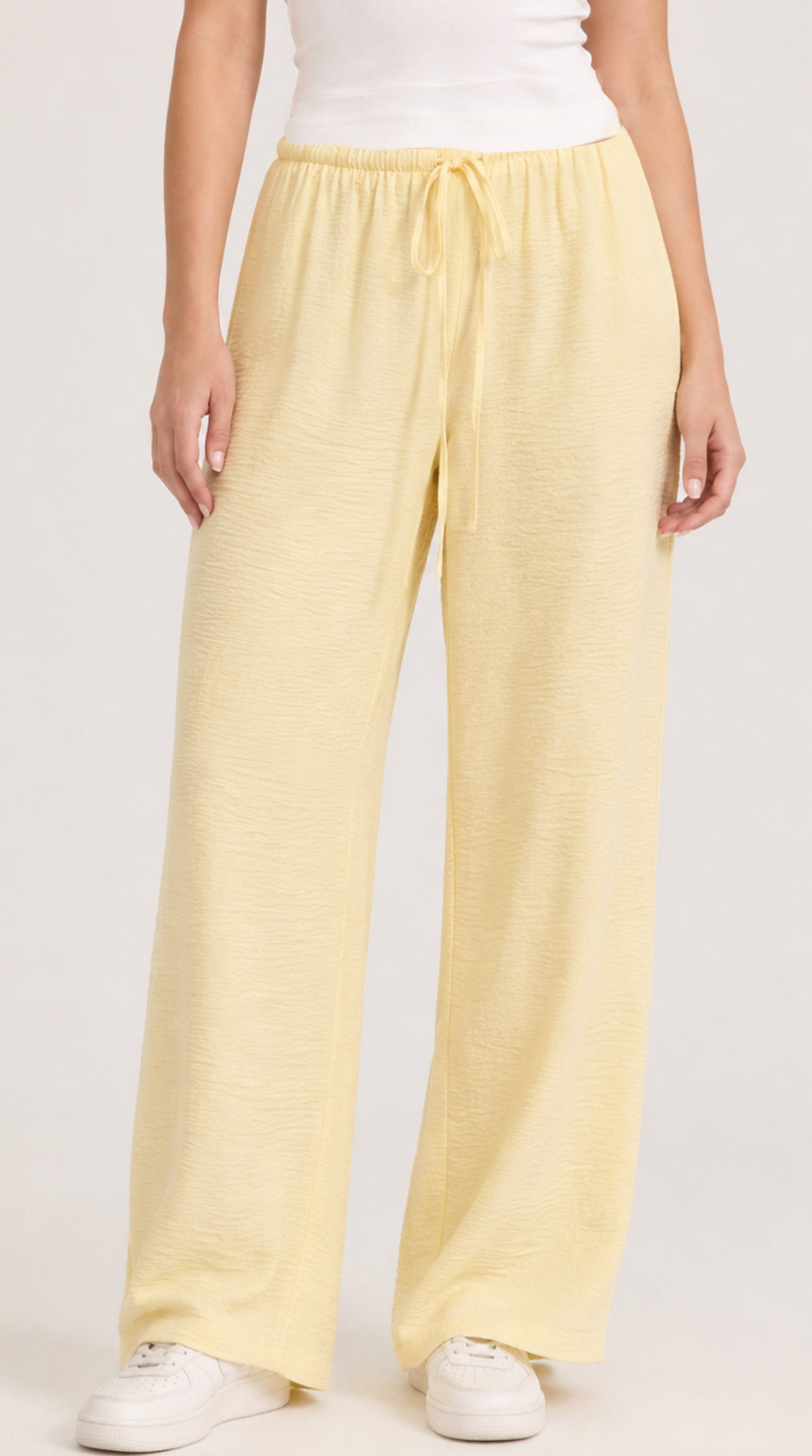 Person wearing light yellow pants on a white background, from Meleche Fashion USA or Meléche (short as (Mé))