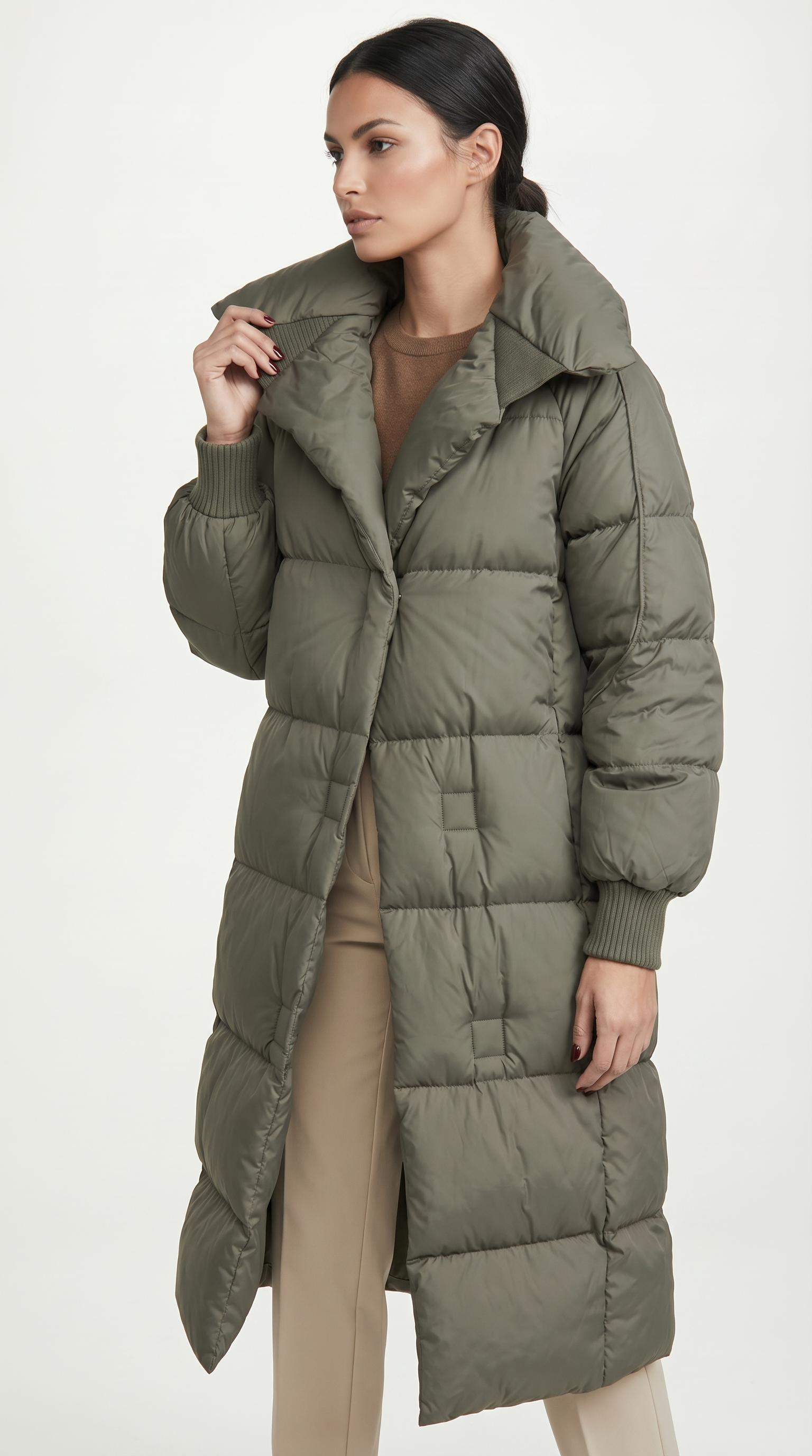 Woman wearing a long olive green puffer coat on a white background from Meleche or Meléche USA (short as (Mé))