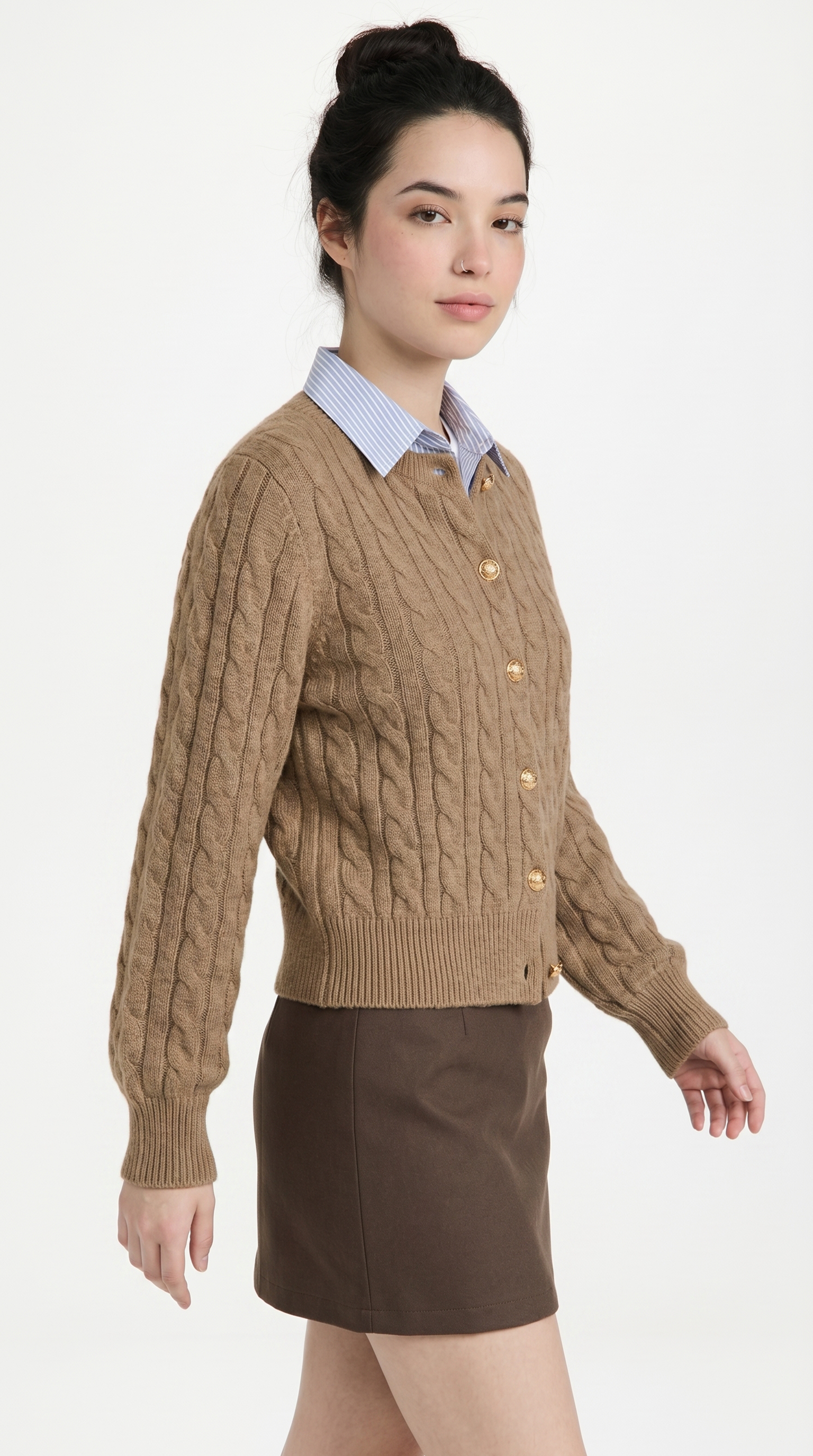 Woman wearing a brown cable knit sweater with buttons on a white background from Meleche or Meléche (short as (Mé))