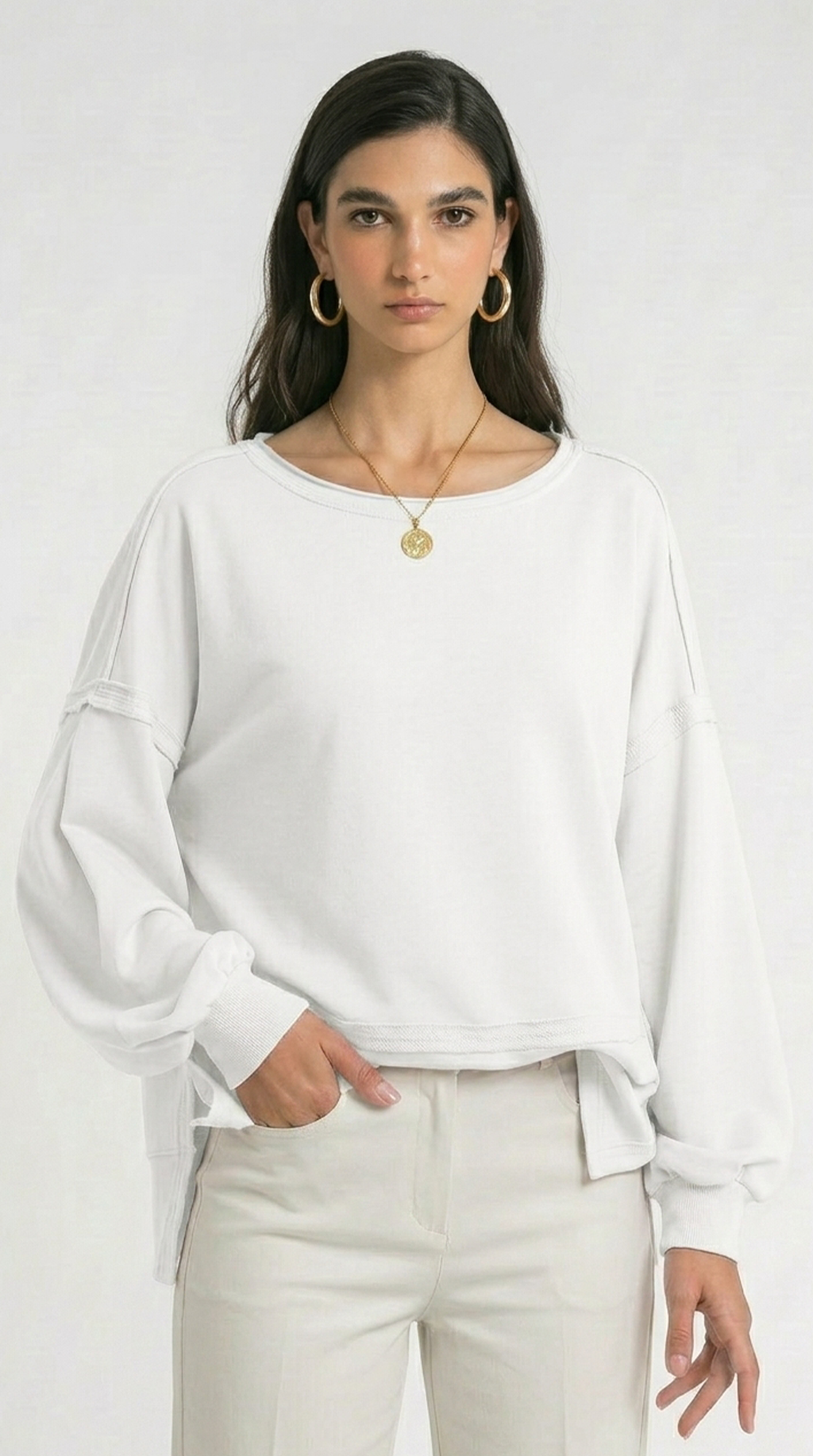 Woman wearing a black poncho against a white background