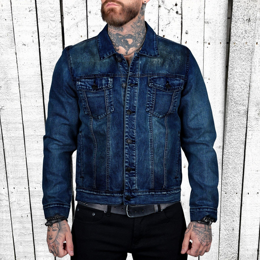 Person wearing a blue denim jacket against a wooden panel background