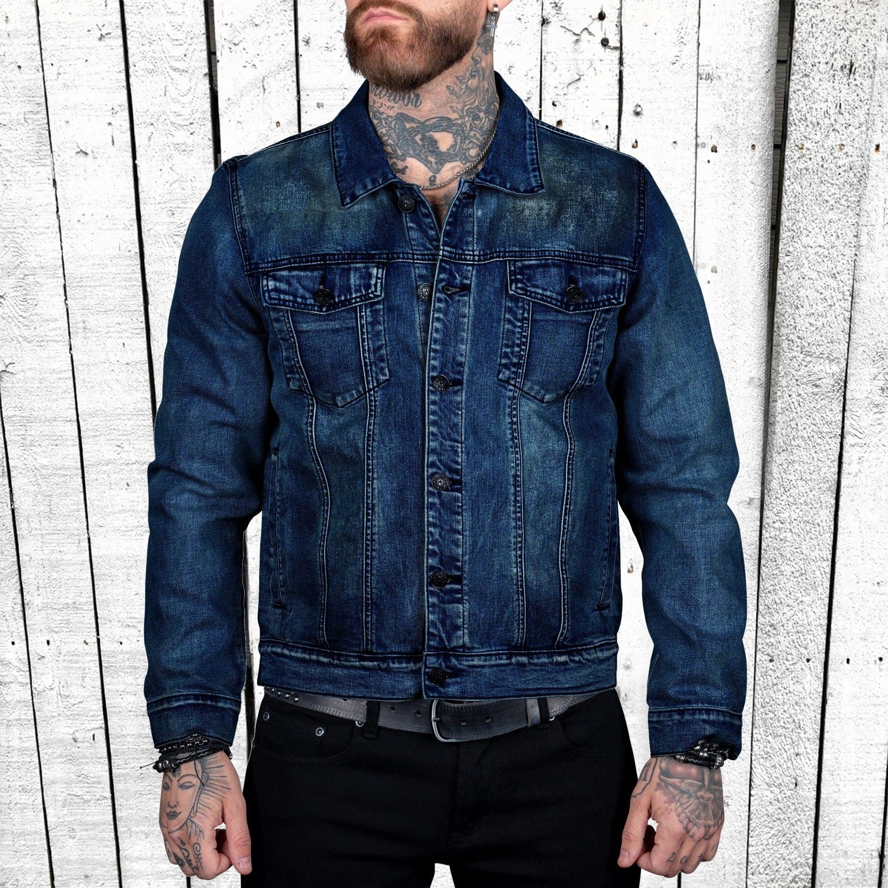 Person wearing a blue denim jacket against a wooden panel background