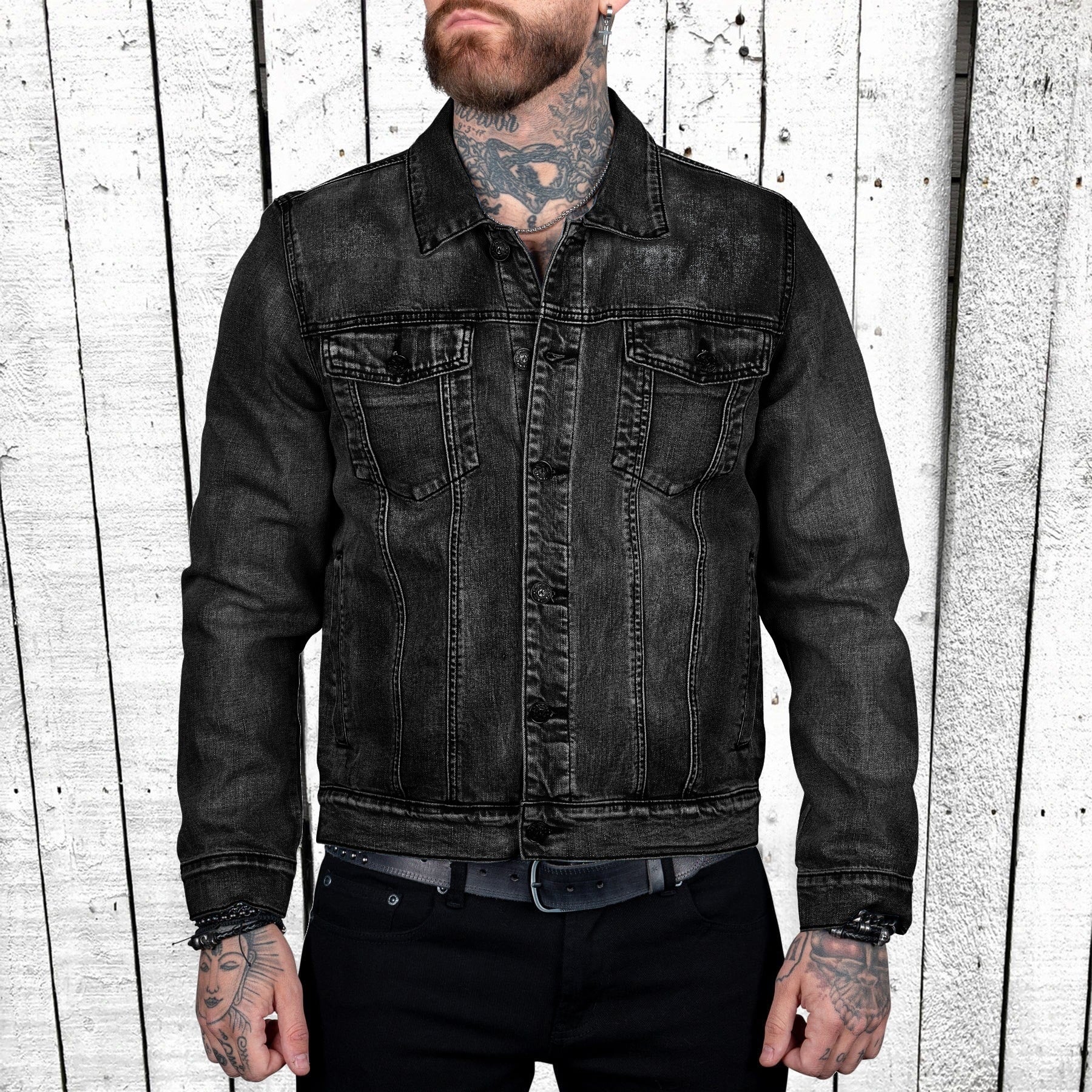 Man wearing a black denim jacket against a wooden panel background