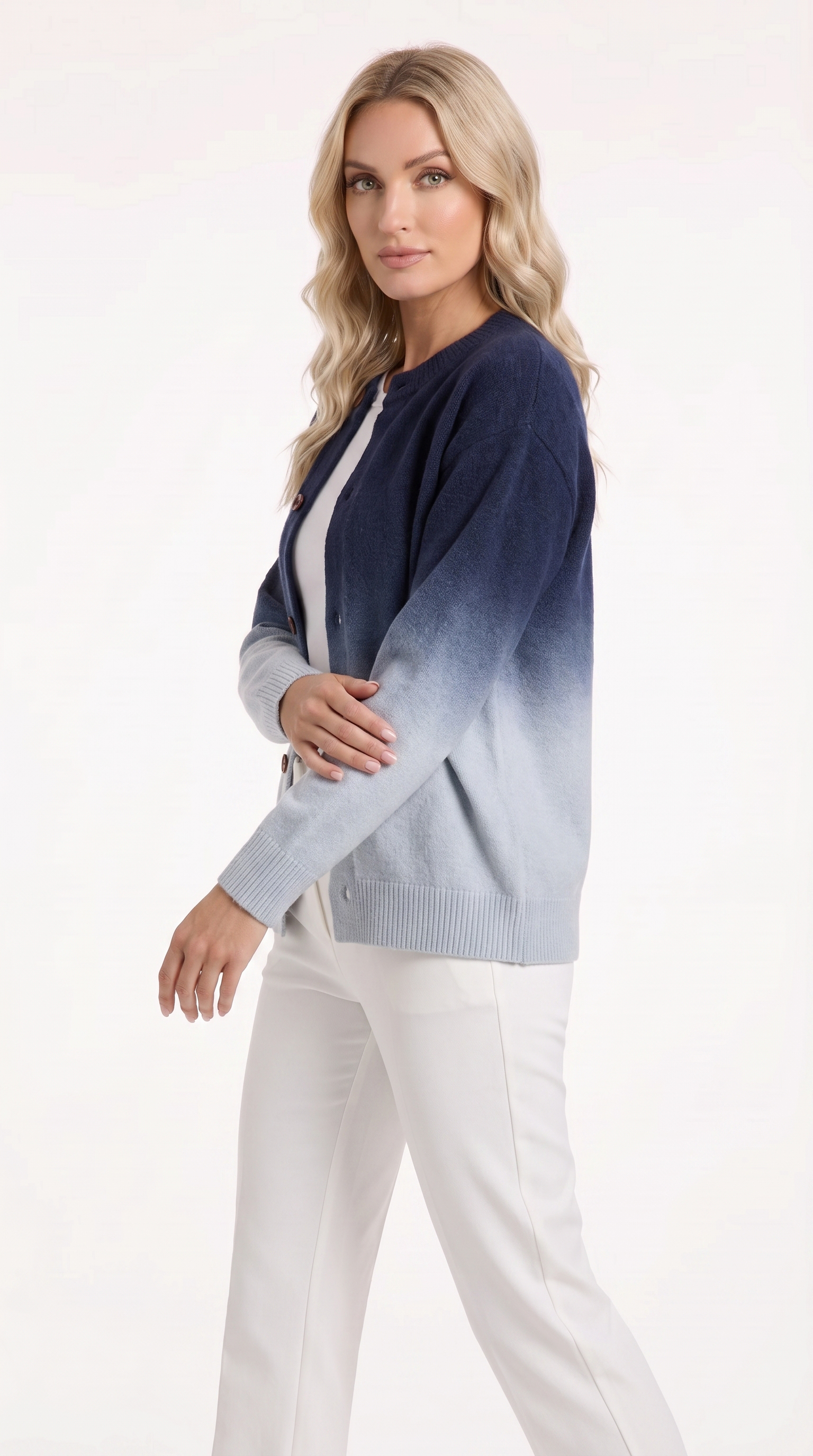 A woman modeling a navy blue cardigan with an ombré fade to light gray, worn over a white top and paired with white pants, against a plain white studio background, from Meleche Fashion USA or Meléche (short as (Mé))