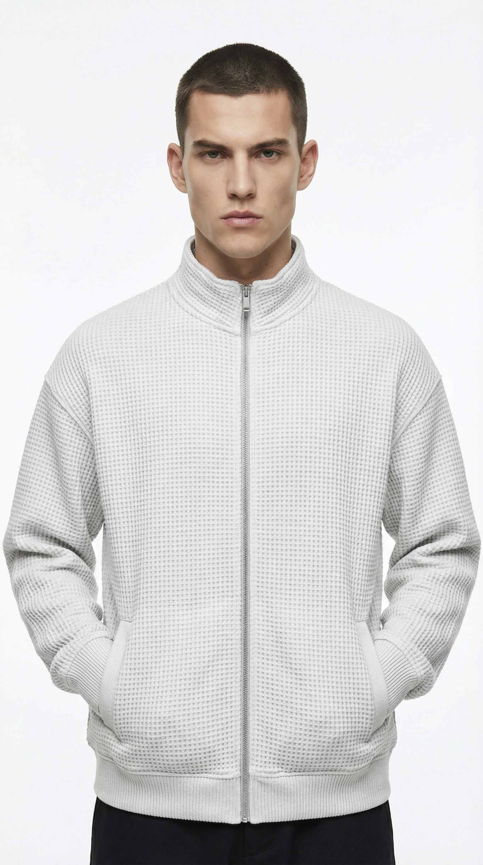 Man wearing a white textured zip-up sweatshirt from Meleche or Meléche (short as (Mé))