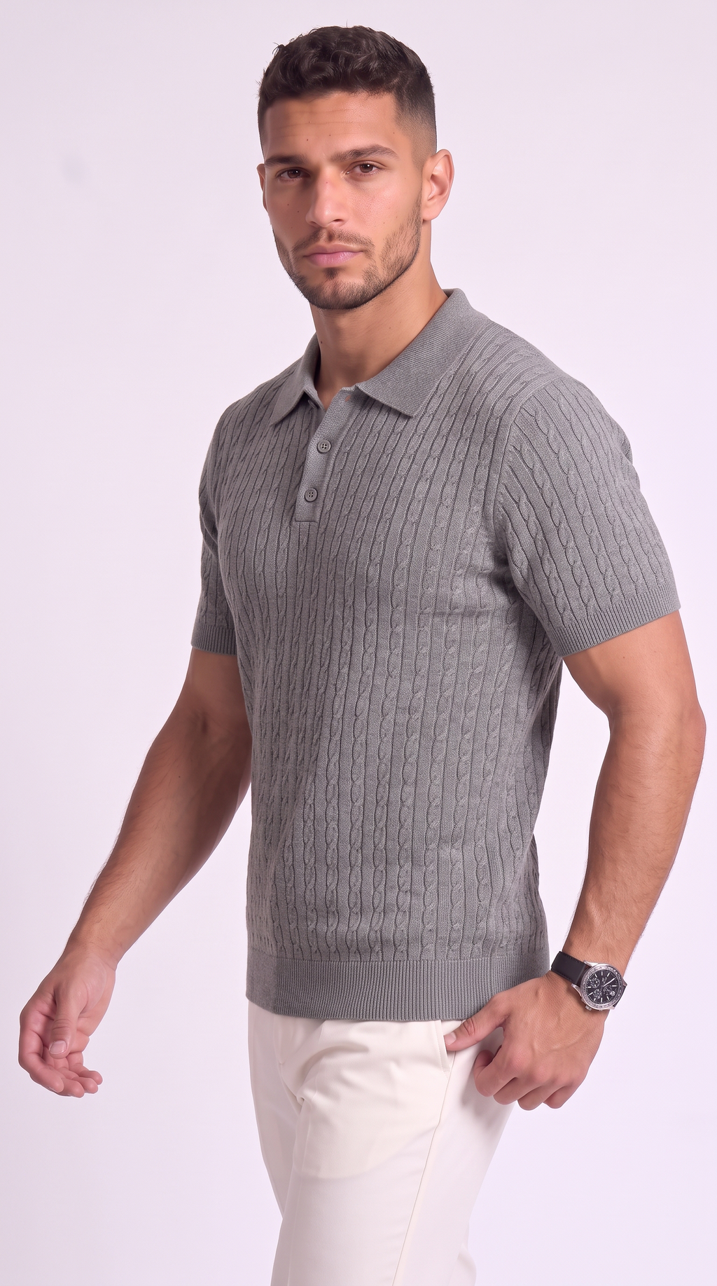 A man wearing a gray short-sleeve polo shirt with a cable-knit pattern and white pants, standing against a light studio background, from Meleche Fashion USA or Meléche (short as (Mé))