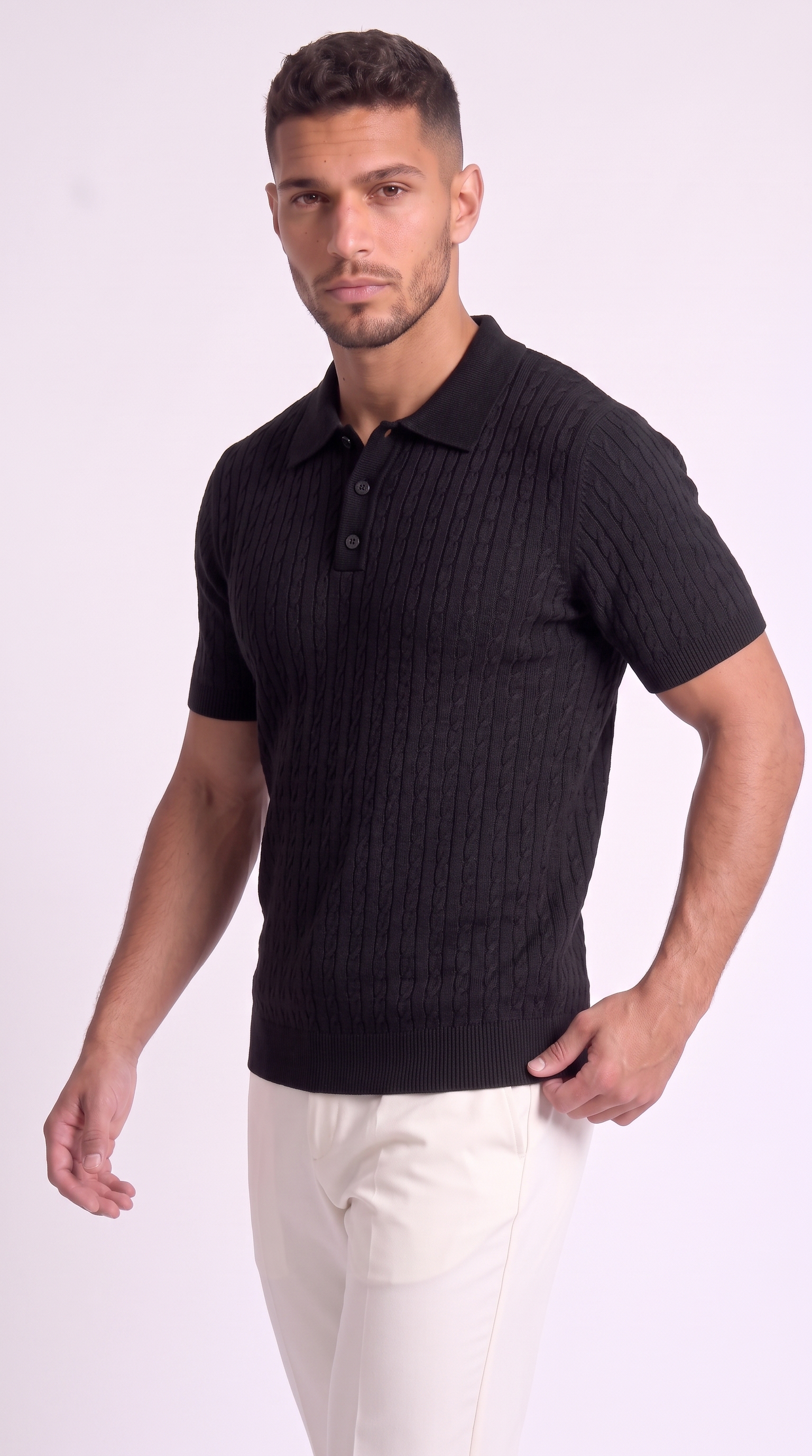 A man wearing a black short-sleeve polo shirt with a ribbed knit texture and white pants, standing against a light studio background, from Meleche Fashion USA or Meléche (short as (Mé))