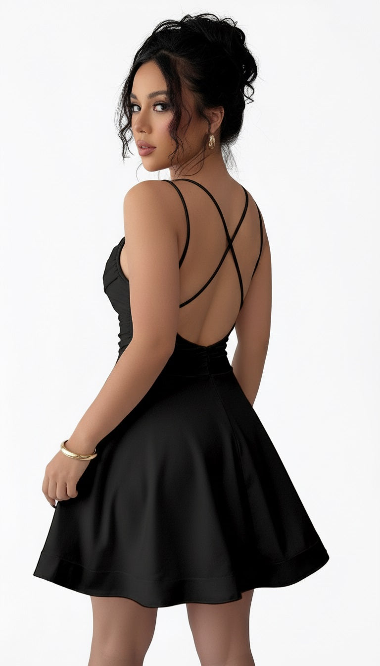 Woman taking a mirror selfie wearing a black dress in a room with a gray wall and white curtain.